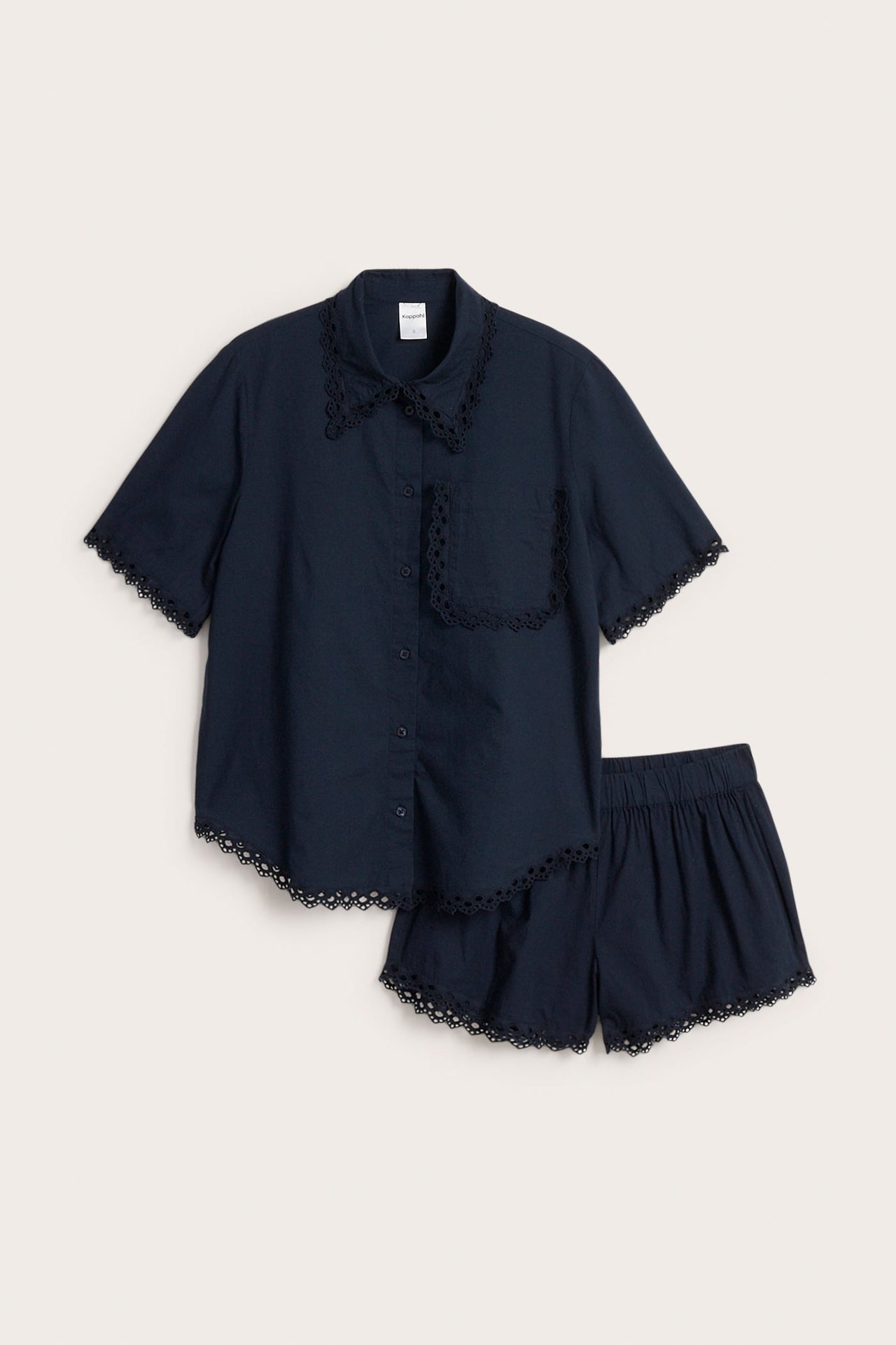 Framsida av en mörkblå kortärmad skjorta och matchande shorts med spetskant.
