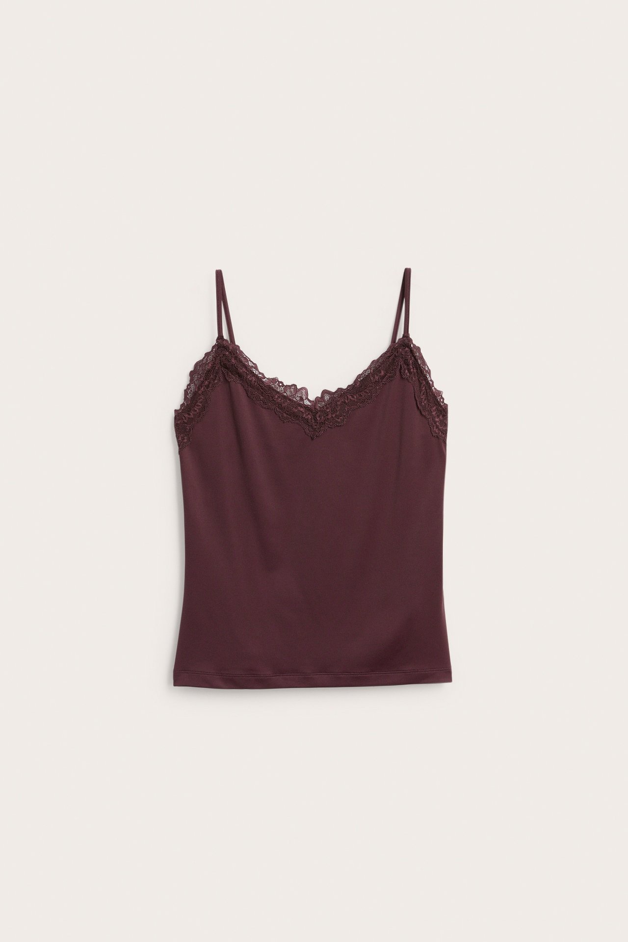 Framifrån, vinröd camisole med smala band och spetsdetaljer i V-ringningen.