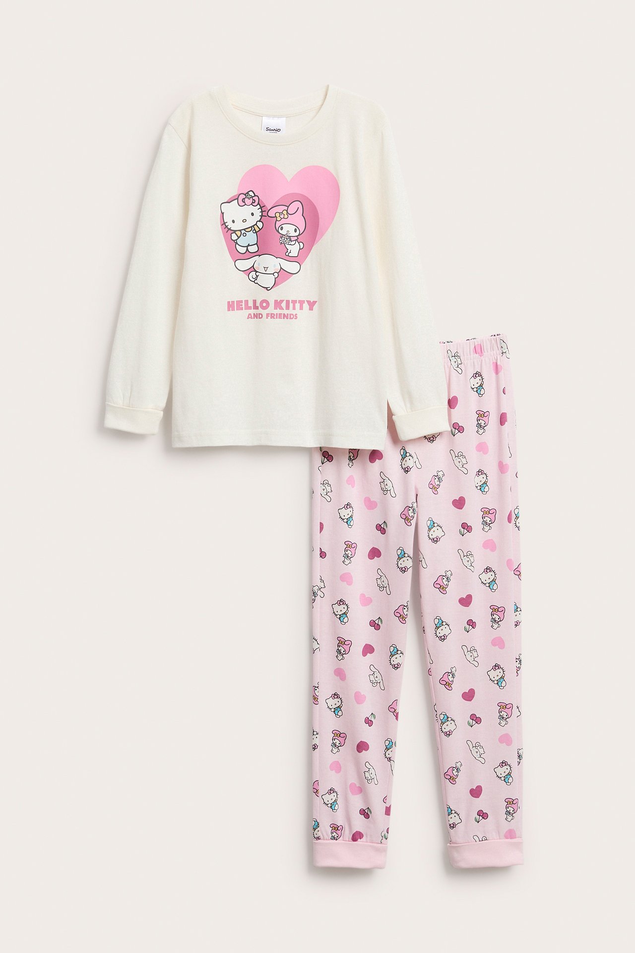 Widok z przodu: Dziecięca piżama Hello Kitty, kremowy top z różowym sercem i różowe wzorzyste spodnie.