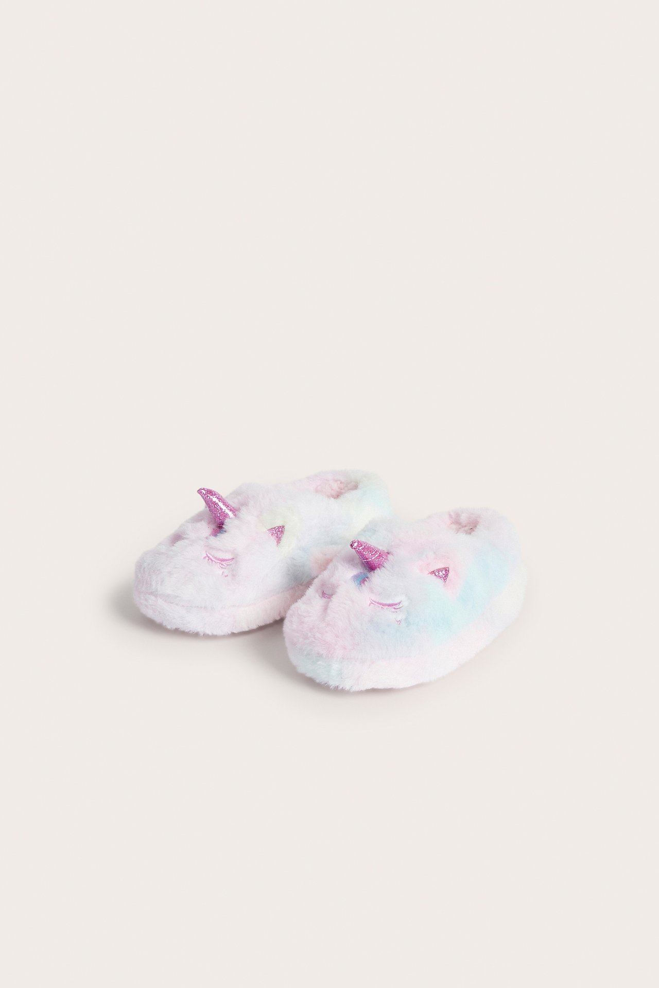 Fremre visning av myke pastell regnbue enhjørnings tøfler med rosa horn.