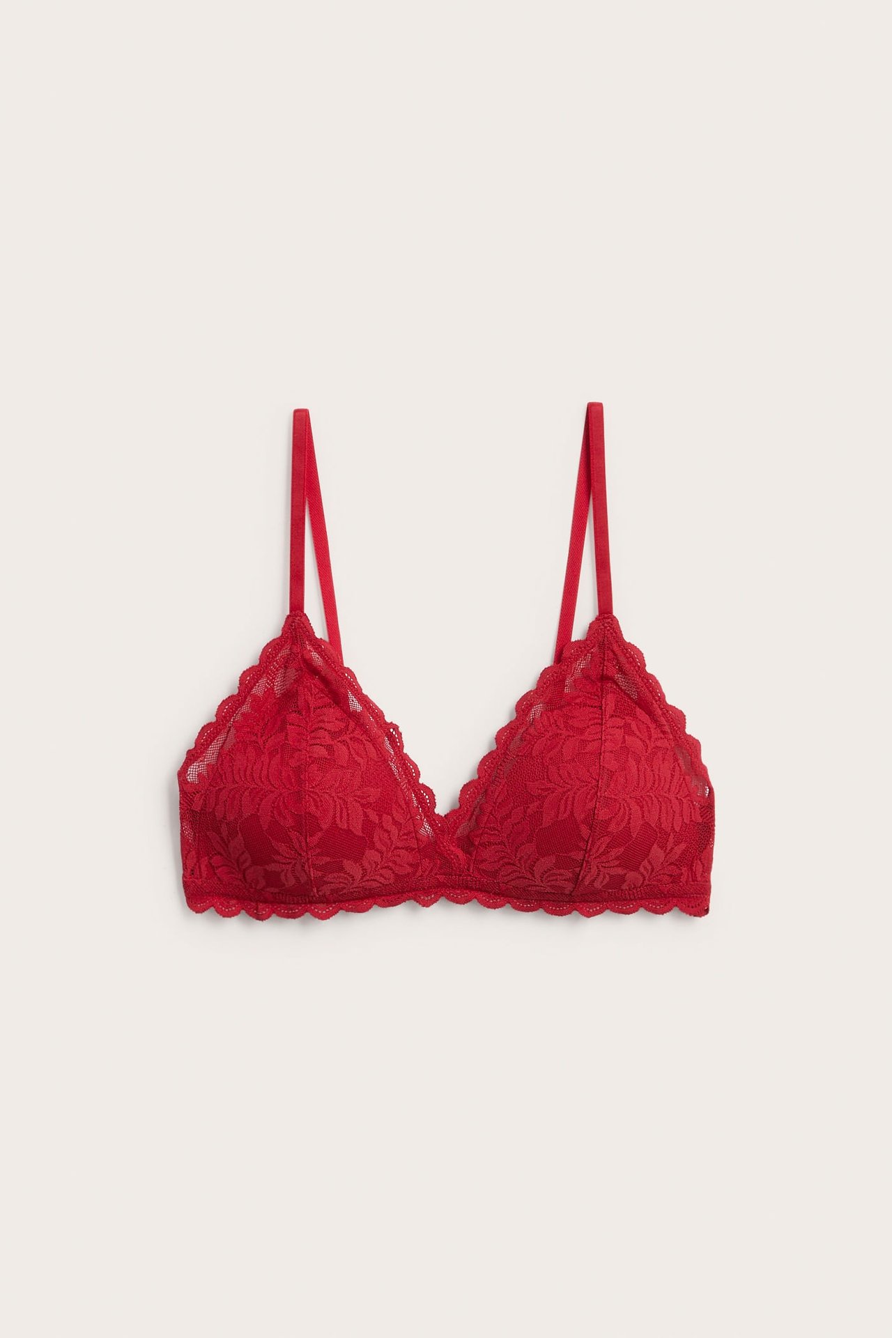 Edestäpäin, punainen pitsibralette, jossa on aaltoilevat reunat ja säädettävät olkaimet.