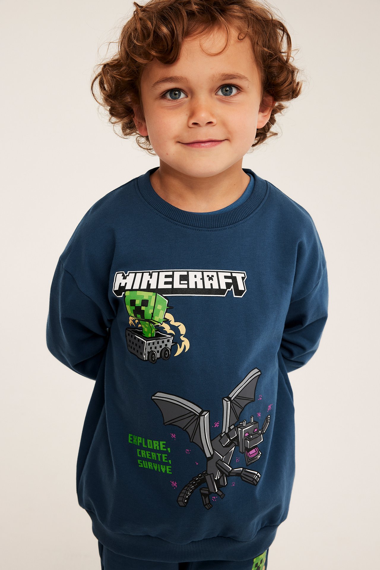 Framsida av ett barn i en mörkblå sweatshirt med Minecraft-tryck.