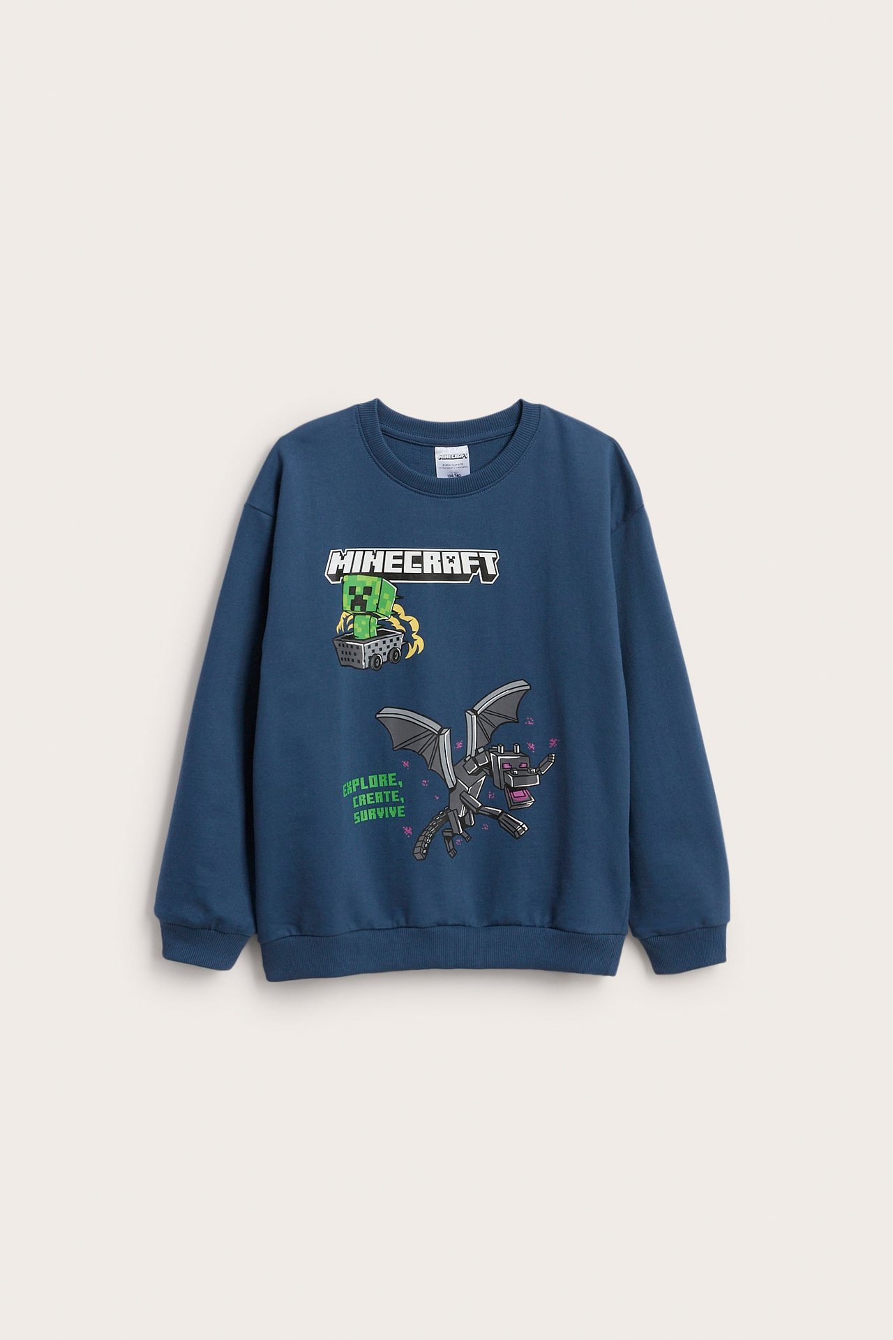 Frontvy av en lös blå barntröja med färgglatt Minecraft-tryck.