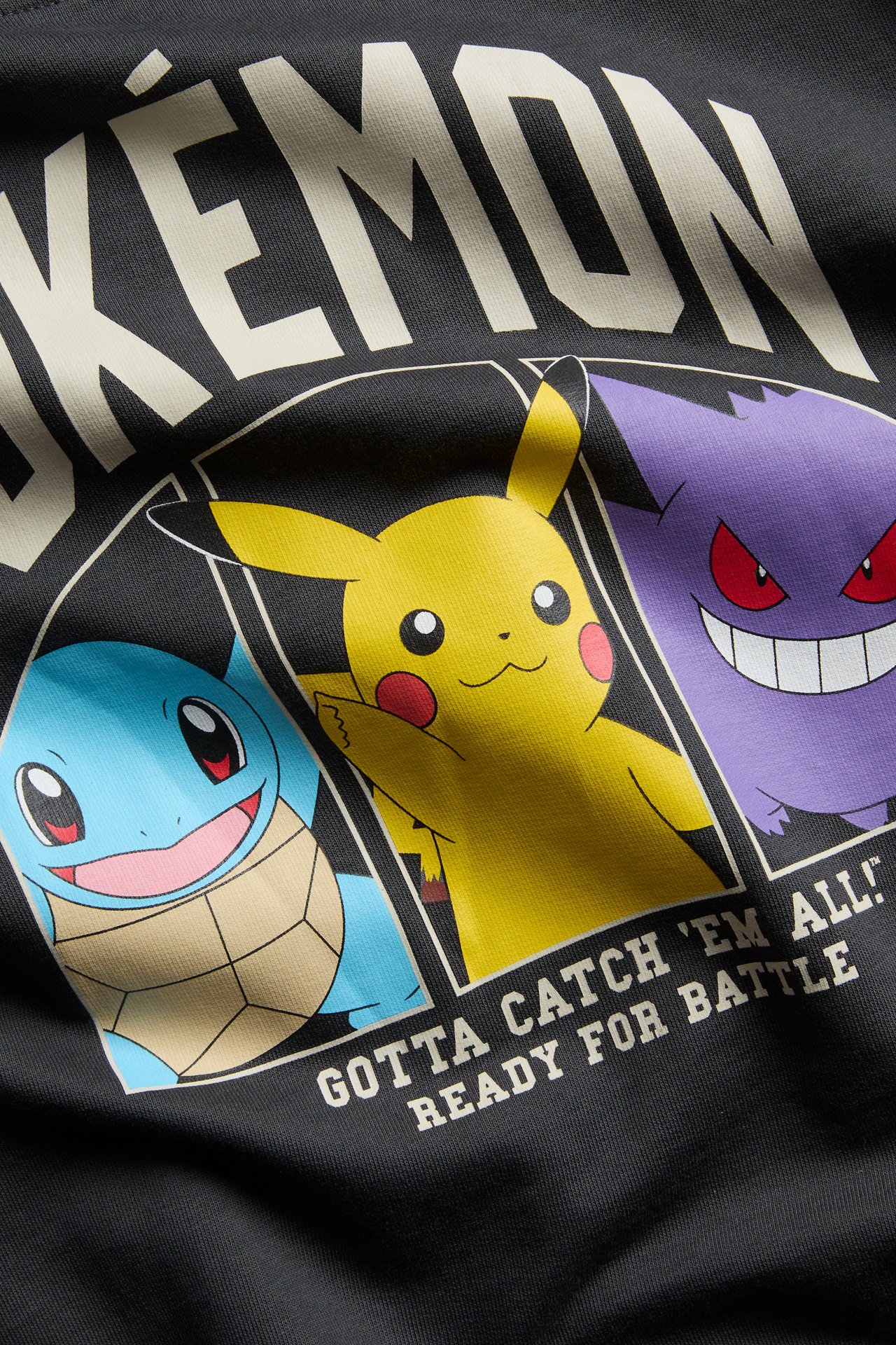 Z bliska widok z przodu ciemnoszarego T-shirtu z kolorowym graficznym nadrukiem Pokémon.