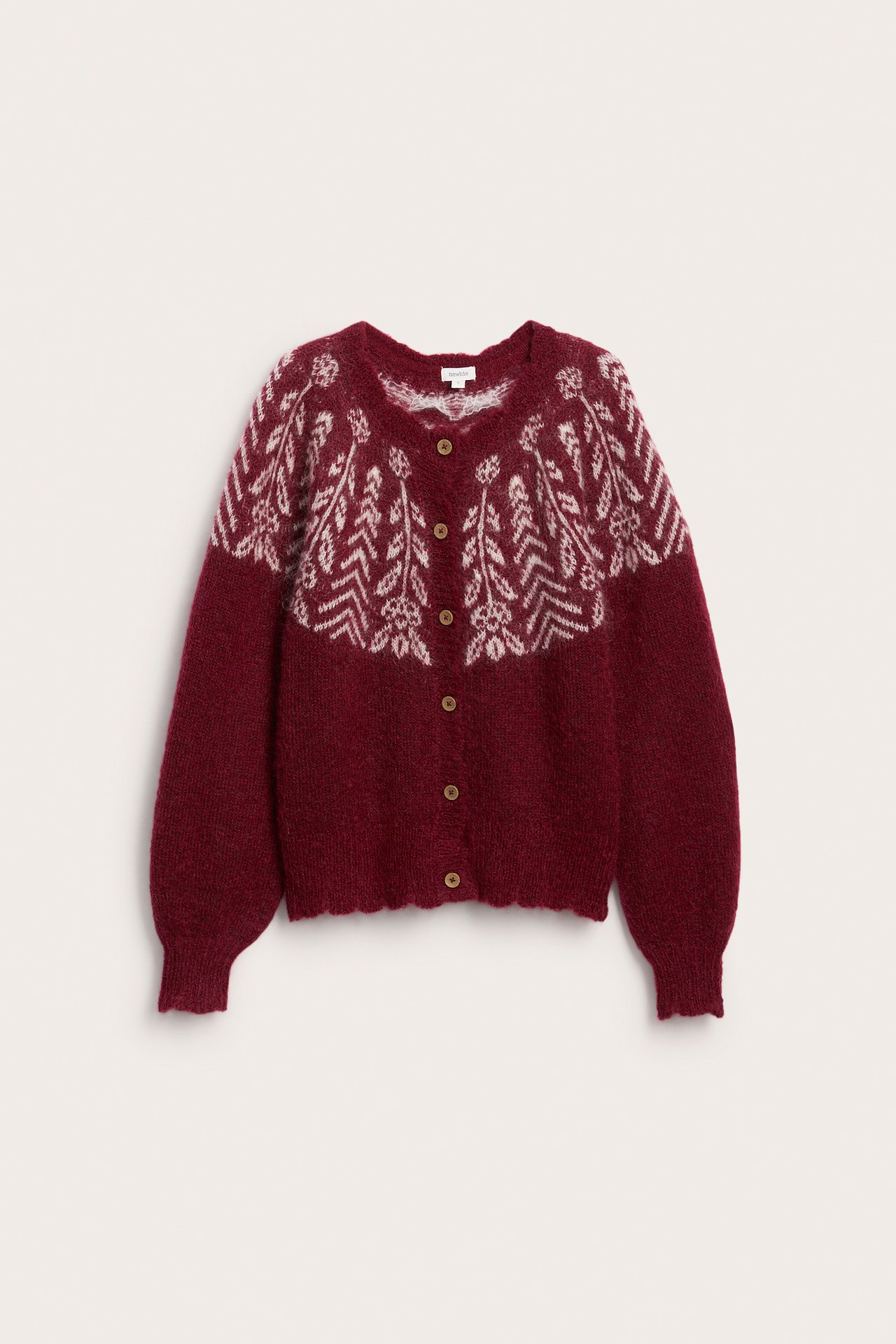 Edestä näkymä burgundinpunaisesta fair isle neuletakista valkoisella kuviolla ja ruskeilla napeilla.