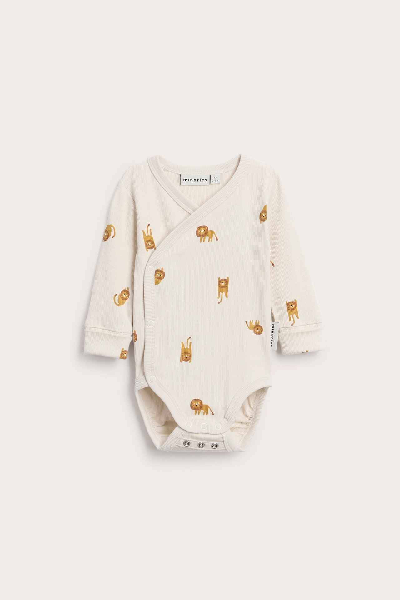Frontutsikt av en baby kremfarget ribbet omslagsbody med lange ermer, løvetrykk og trykknapper.