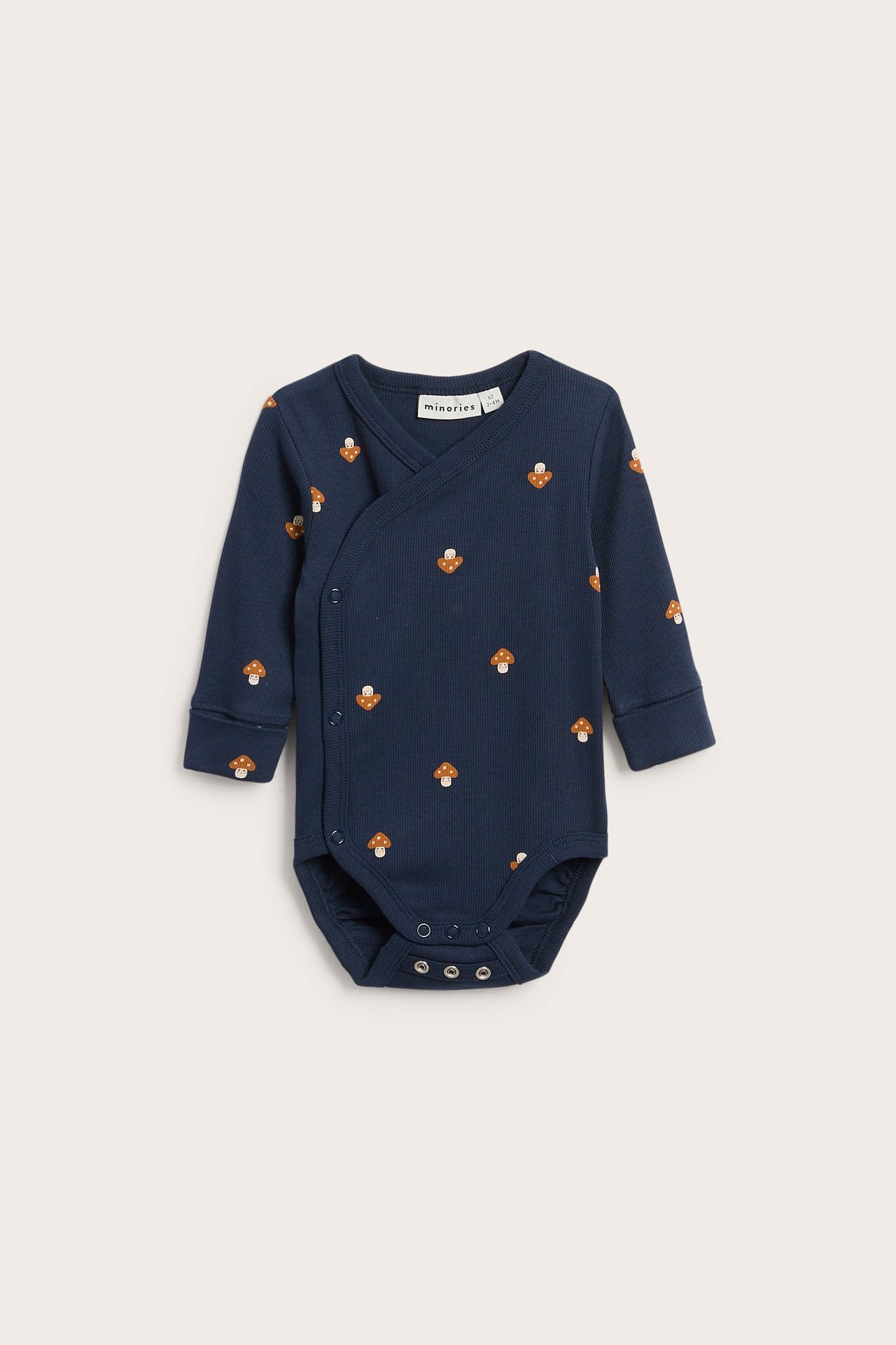 Frontbilde av marineblå ribbet babybody med lange ermer, soppmønster og trykknapper.