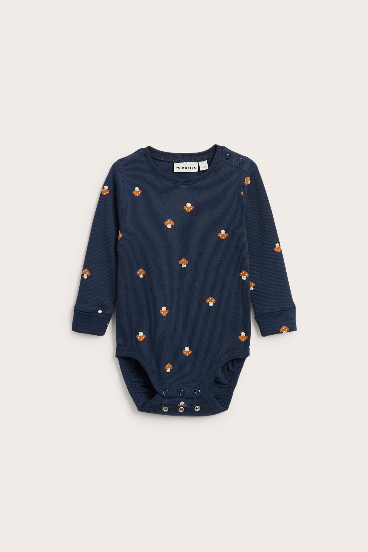 Framifrån, mörkblå långärmad babybody med svamptryck och tryckknappar.