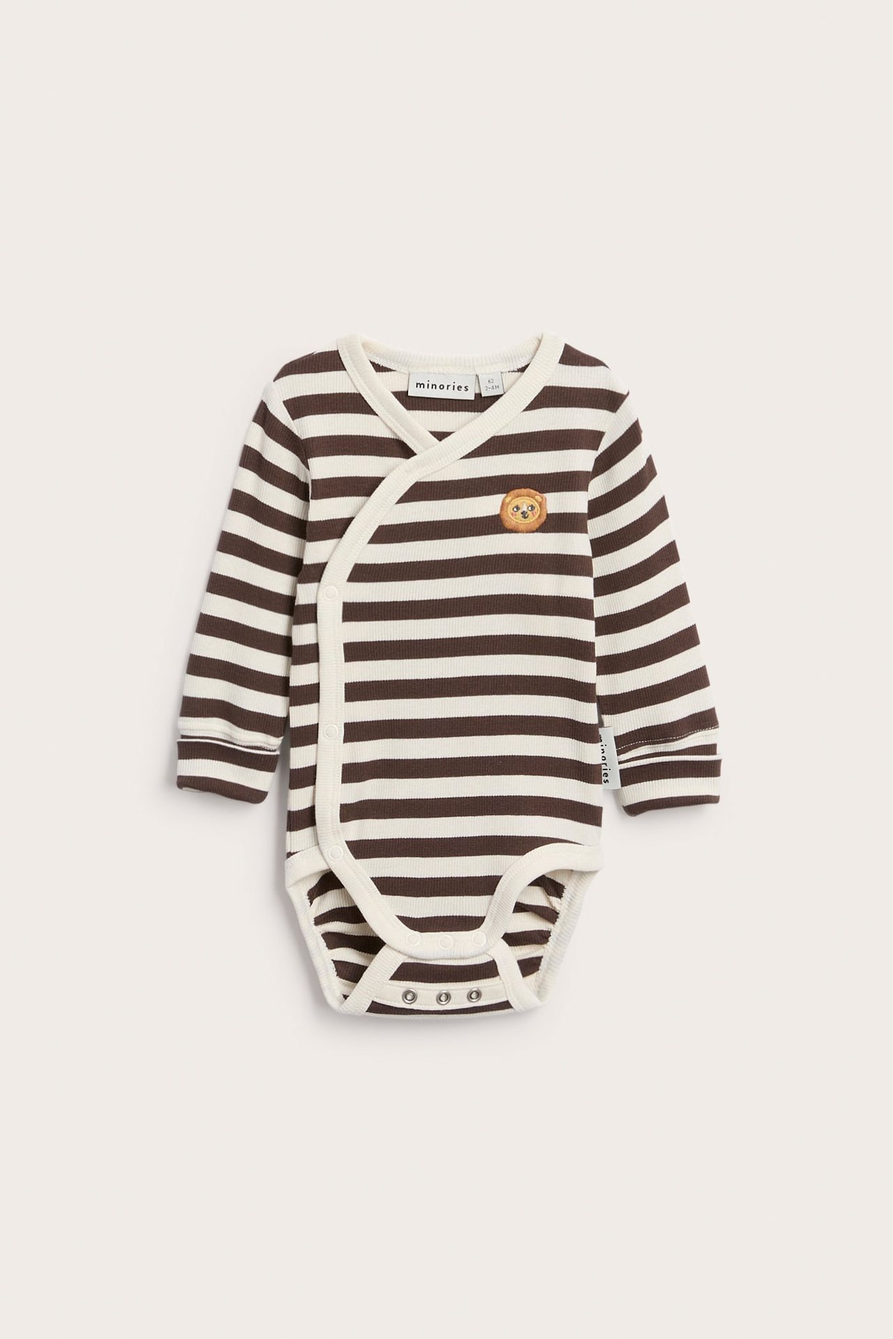 Frontbilde av en baby langermet brun og hvit stripete omslagsbody med løvebroderi.