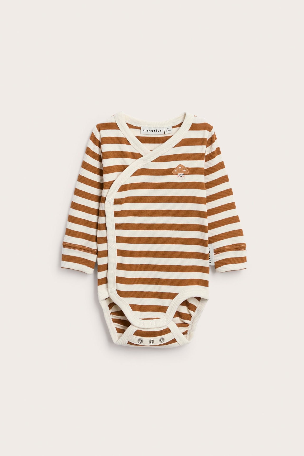 Forfra av en baby langermet stripete omslagsbody med soppbroderi.