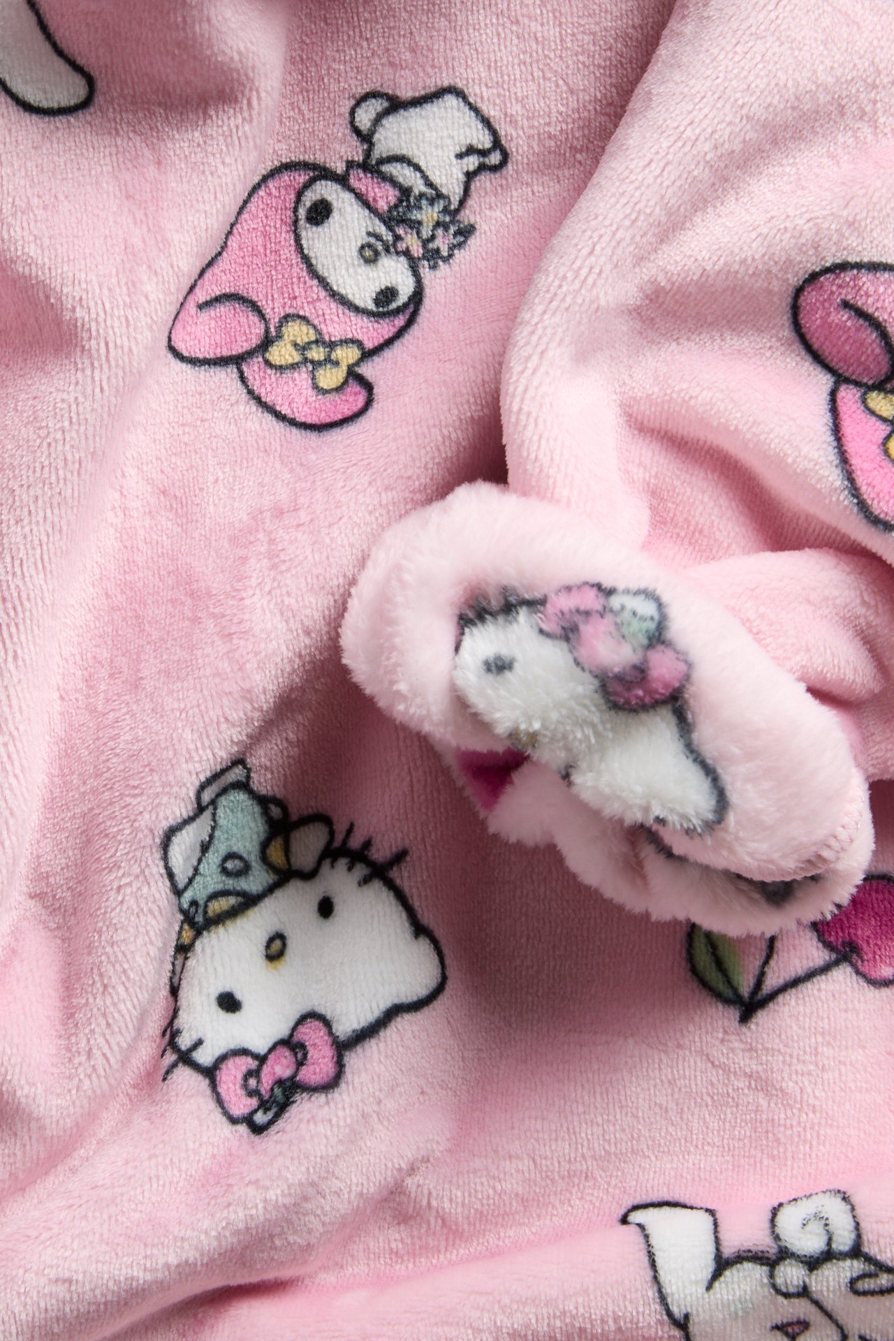 Lähikuva vaaleanpunaisesta fleecehupparista, jossa on toistuva Hello Kitty -hahmokuvio.