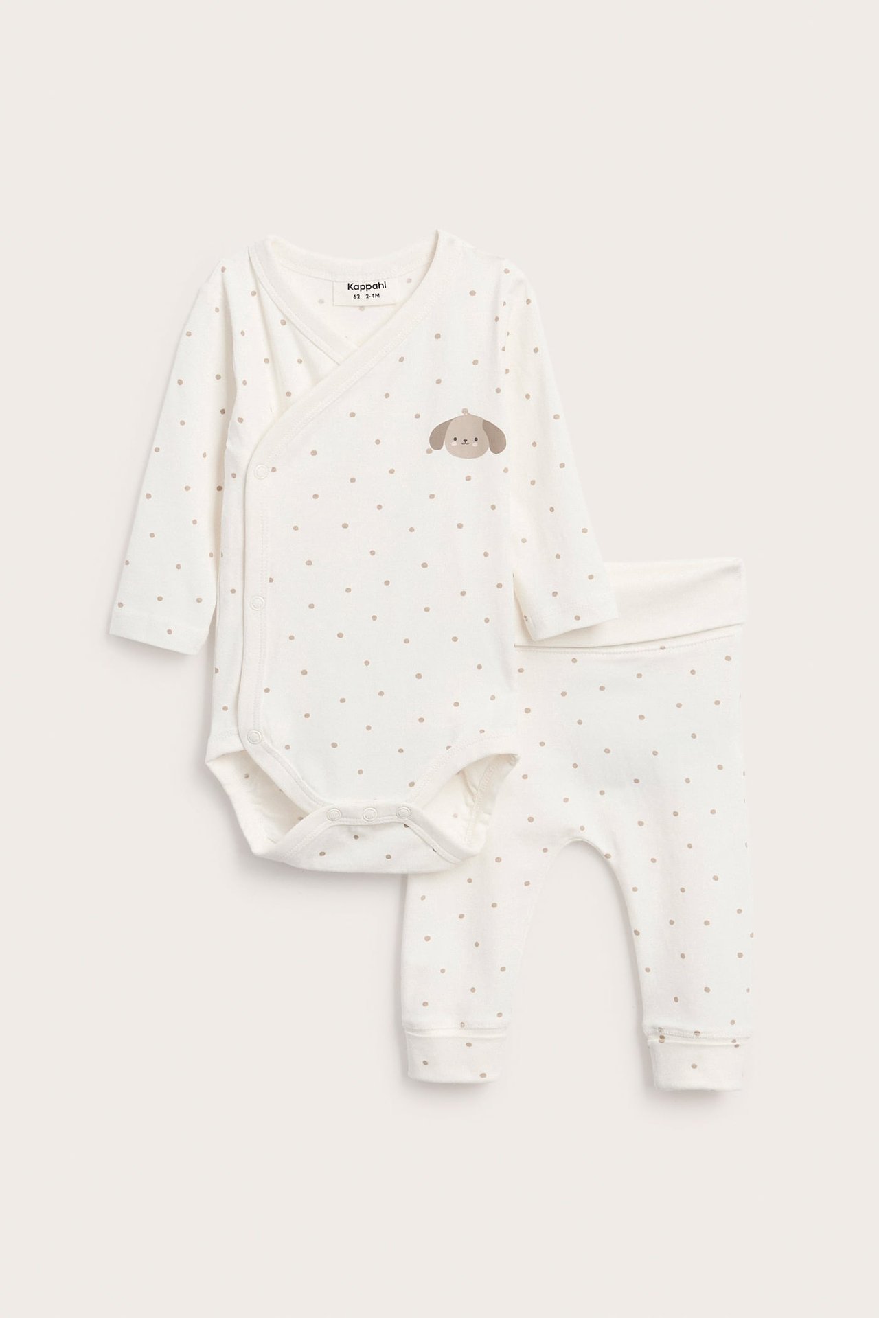Framifrån: vit långärmad babybody med prickar och valptryck, med matchande byxor.