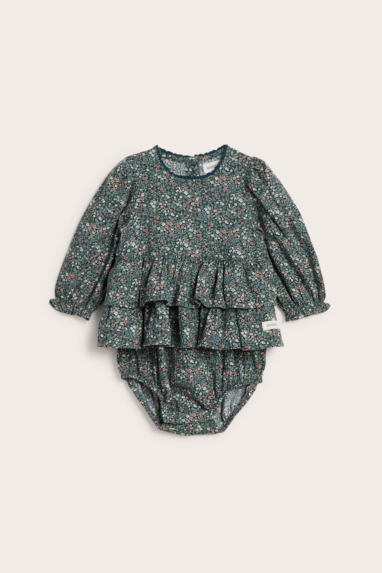 Forfra: babysett i to deler med grønt blomstermønster, volangtopp og bloomer-truse.