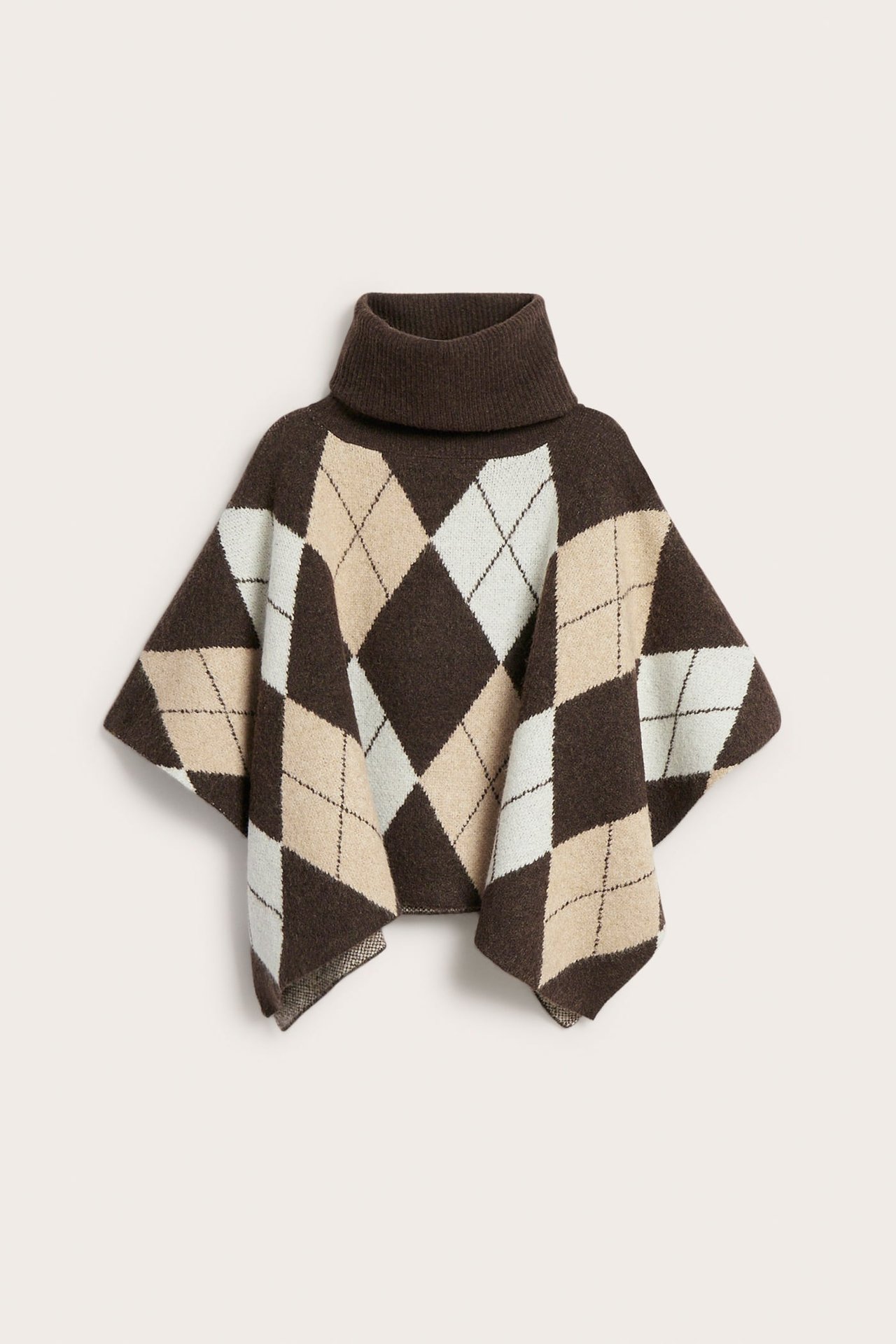 Edestä näkymä: Ruskea neulottu argyle-pooloneuleponcho, jossa beigen ja valkoisen värisiä ruutuja.