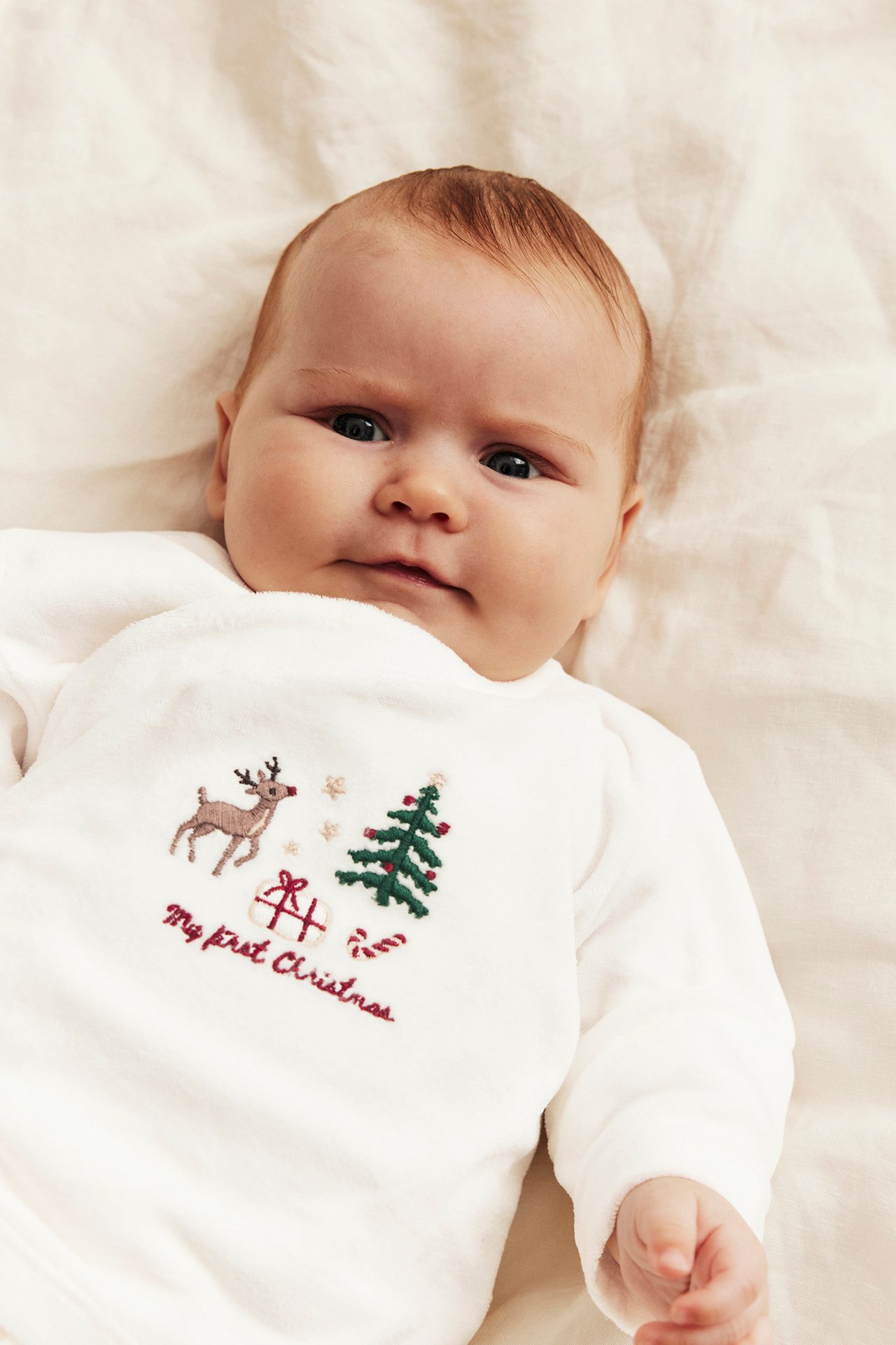 Babys hvit brodert "My first Christmas" langermet topp, nærbilde.