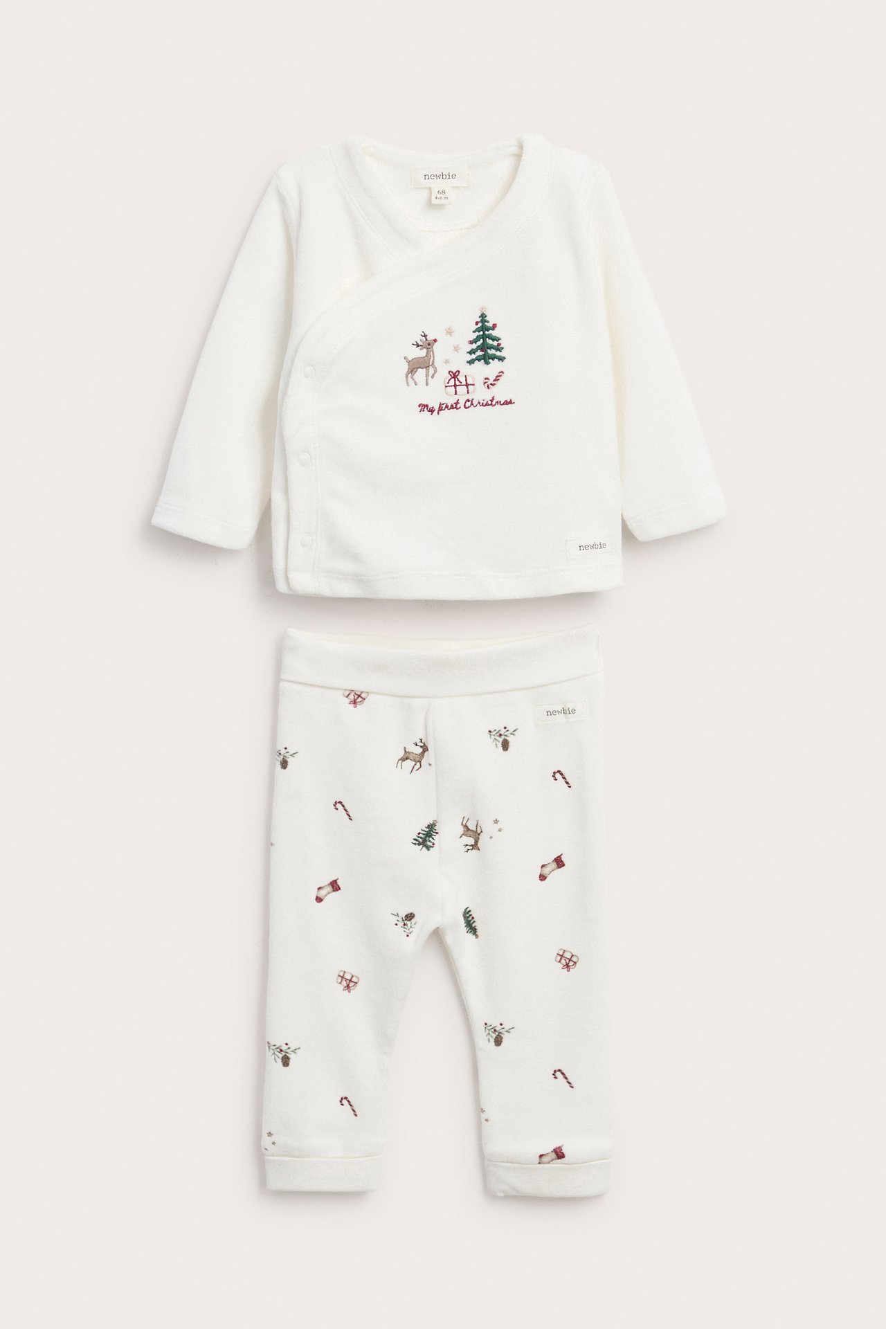 Babys kremhvite juleomslagstopp med brodert reinsdyr og bukser med juletrykk, forfra.