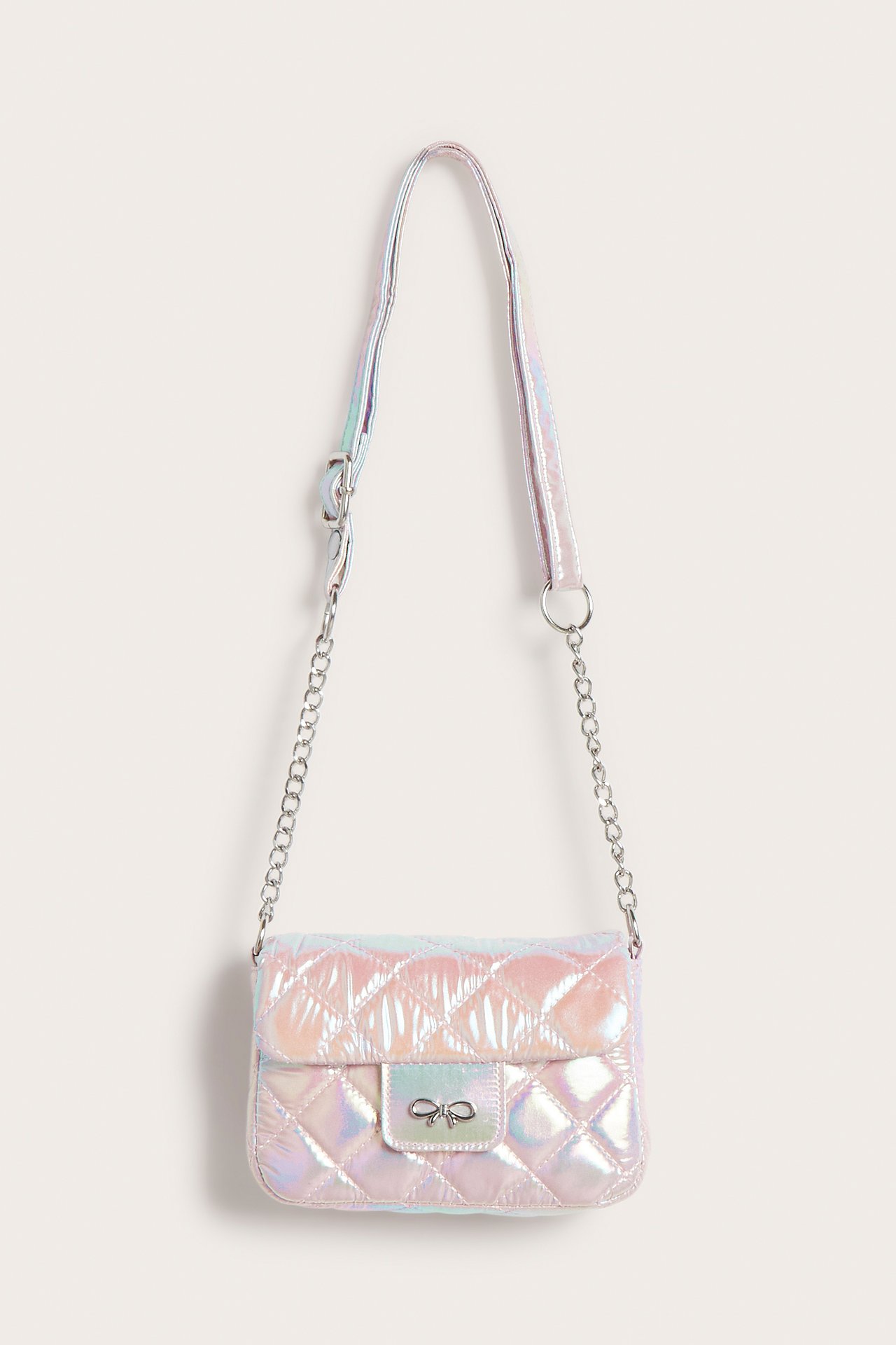 Widok z przodu pikowanej, opalizującej torebki crossbody z łańcuszkiem i zapięciem z kokardką.