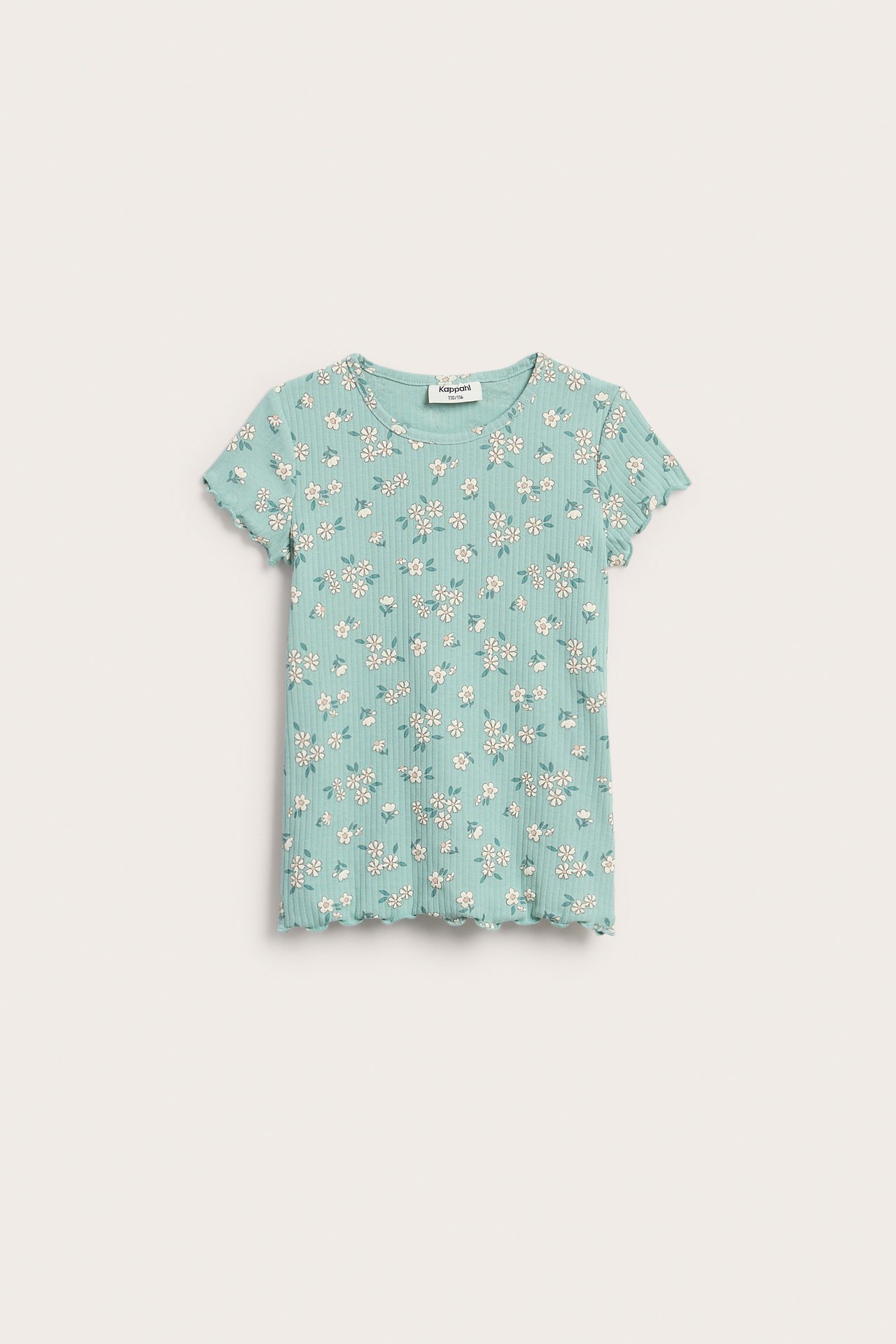 Framifrån, ett barns ljusblå ribbade t-shirt med vitt blommönster och volangdetaljer.