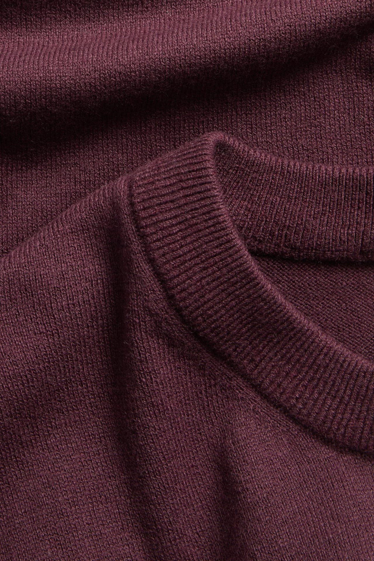 Zbliżenie na bordowy melanżowy sweter z mieszanki wełny z prążkowanym okrągłym dekoltem.