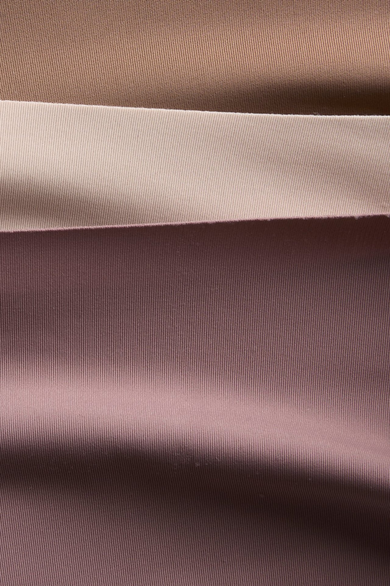 Nærbilde av tre lagdelte ribbestoffprøver i lysebrun, beige og gammelrosa.