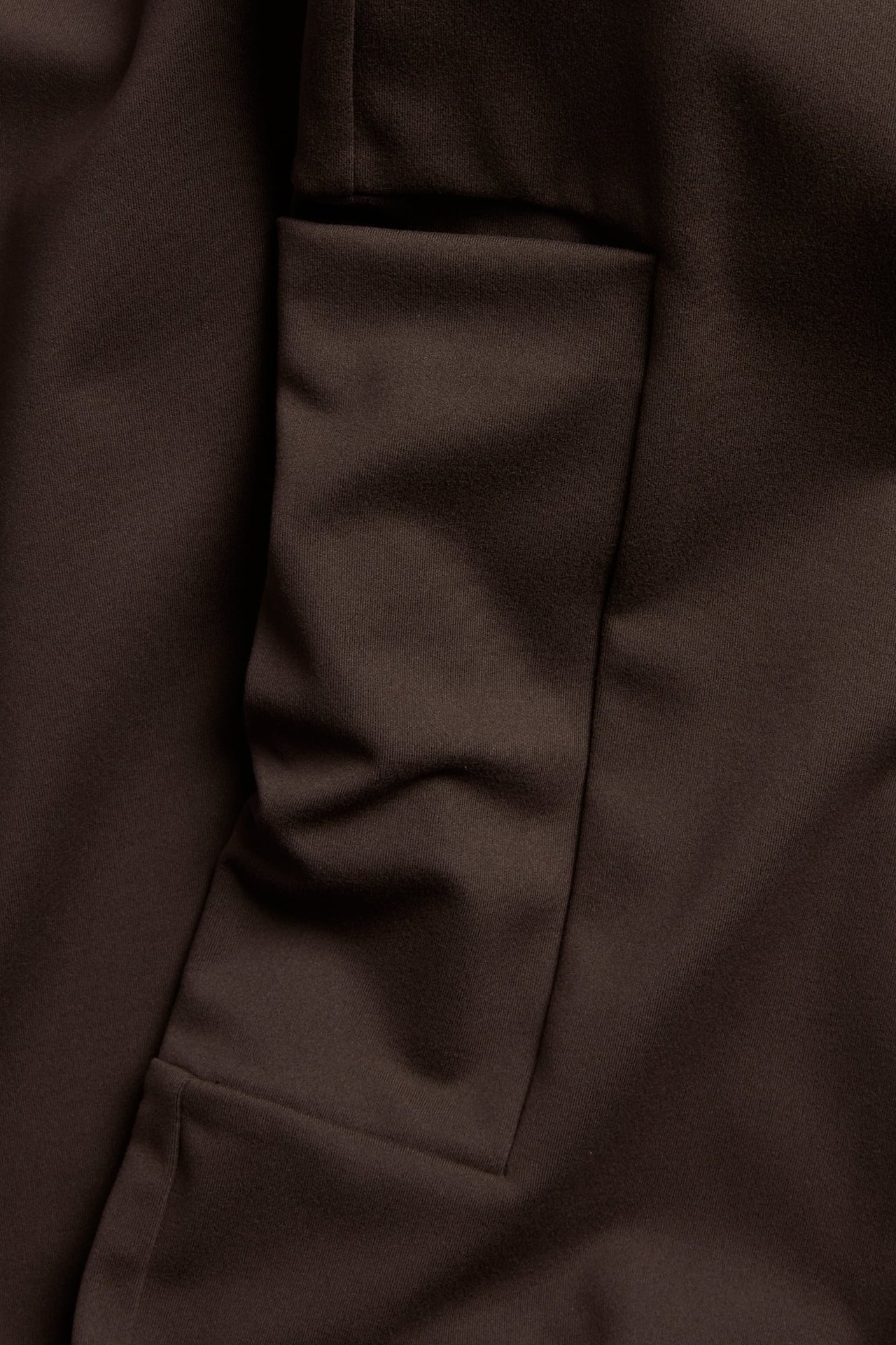 Zbliżenie na brązowe ubranie z tkaniny z kieszenią z klapką.