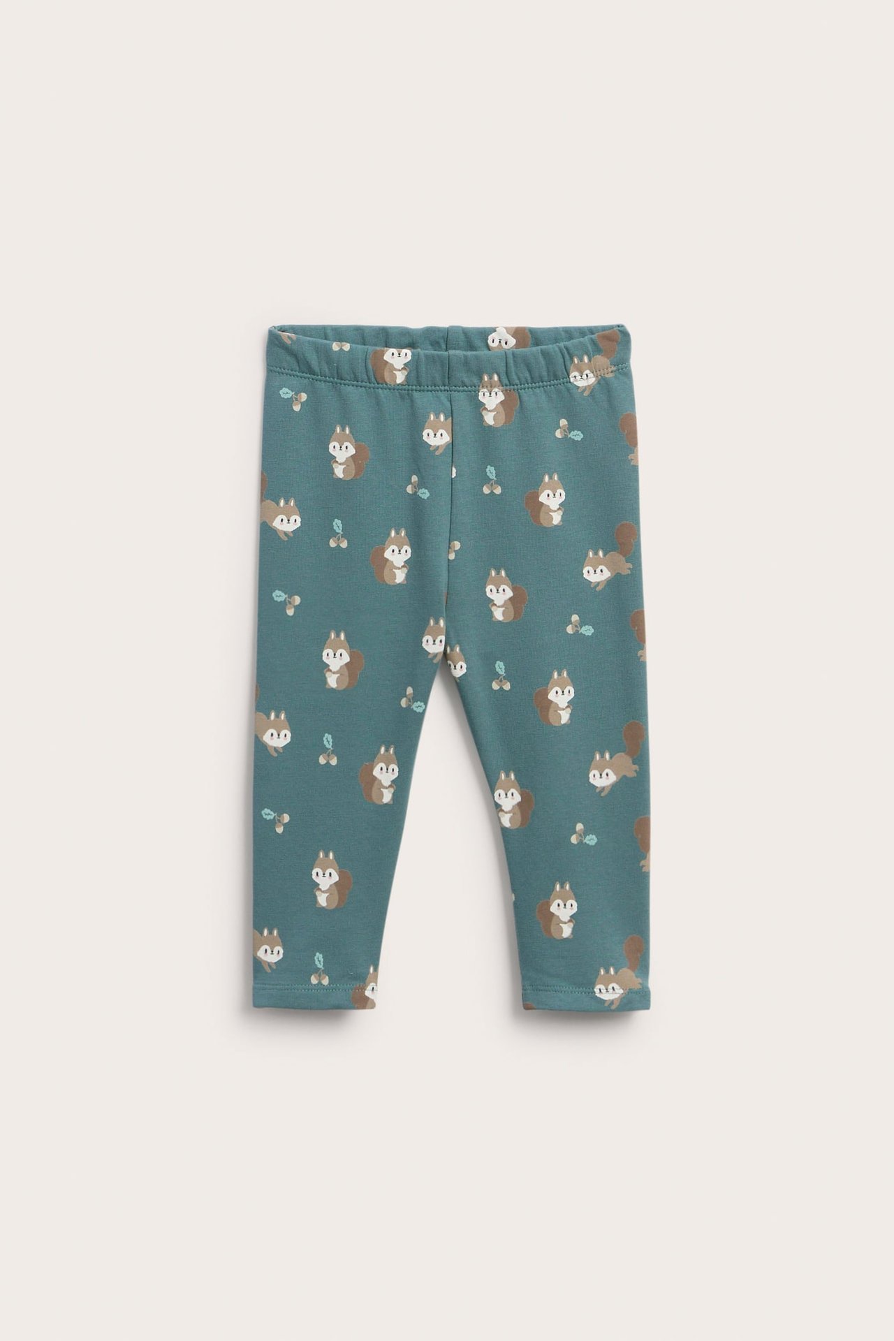 Framifrån, teal baby-leggings med heltäckande tryck av ekorrar och bär.