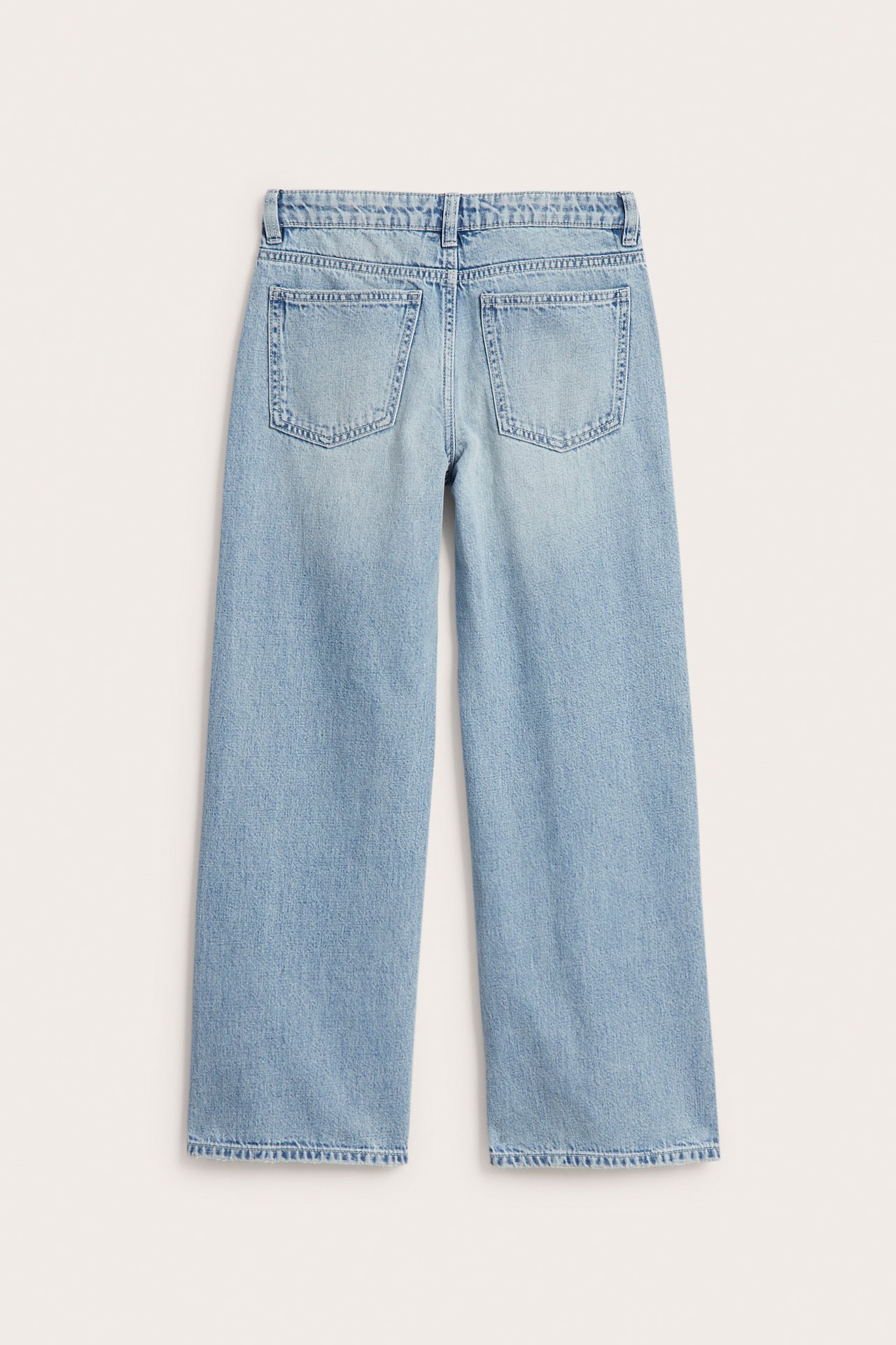 Bakifrån av ljusblå denimjeans med vida ben och synliga bakfickor.