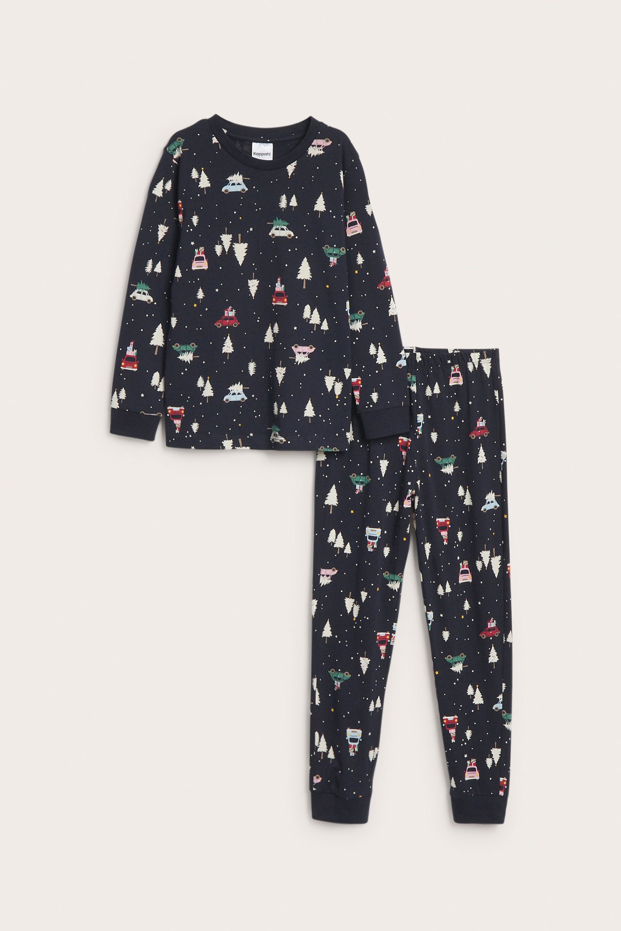Edestäpäin, lasten tummansininen pyjamapuku talviauto- ja puukuviolla.