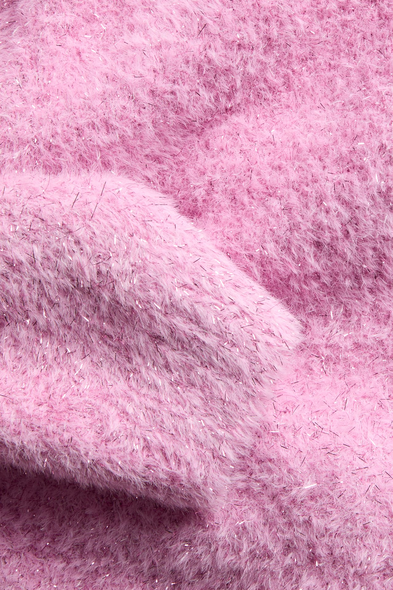 Närbild på rosa fluffigt tyg med silverglänsande trådar.