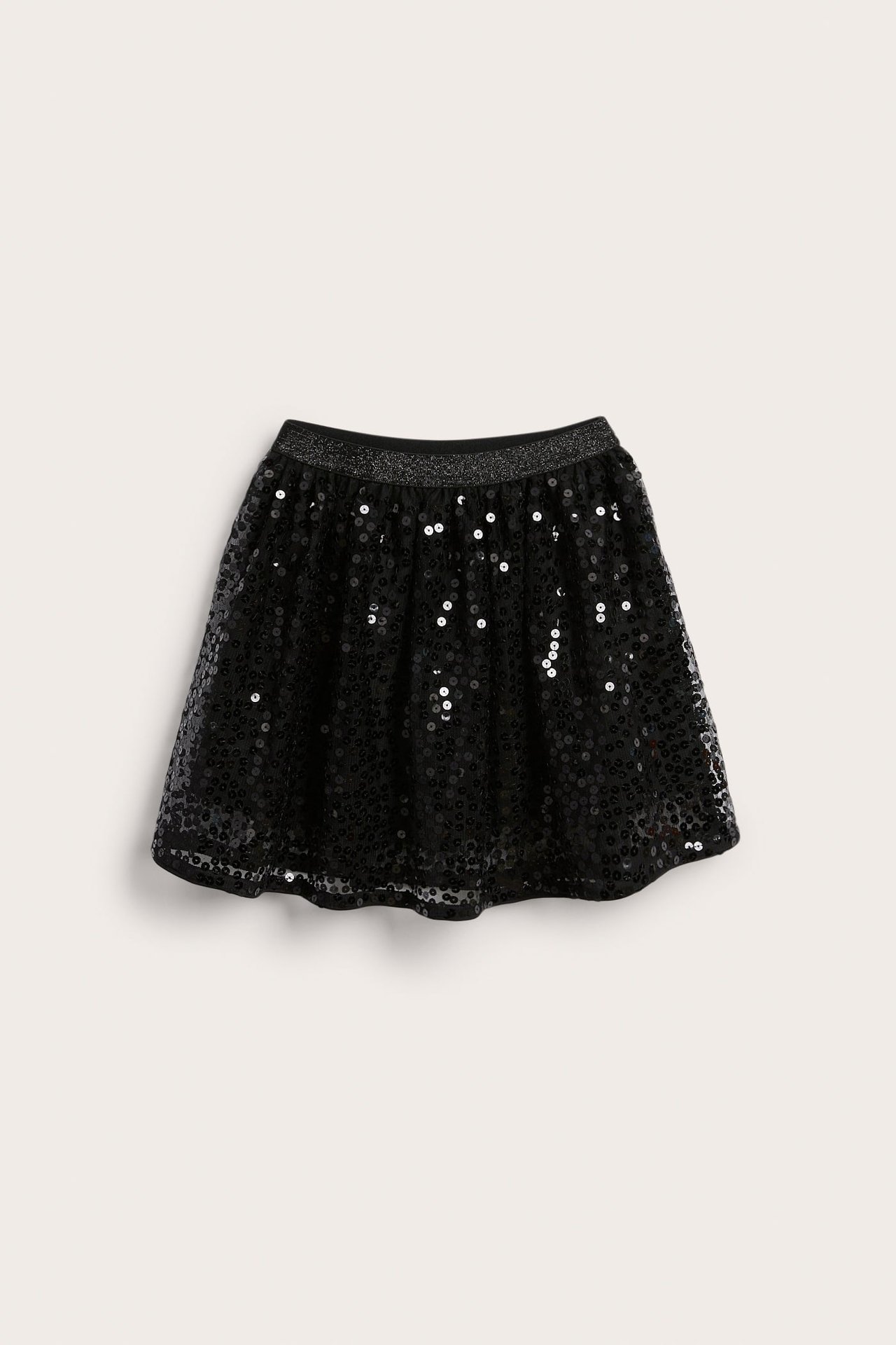 Framsida av en svart paljettkjol för barn med glittermidja.