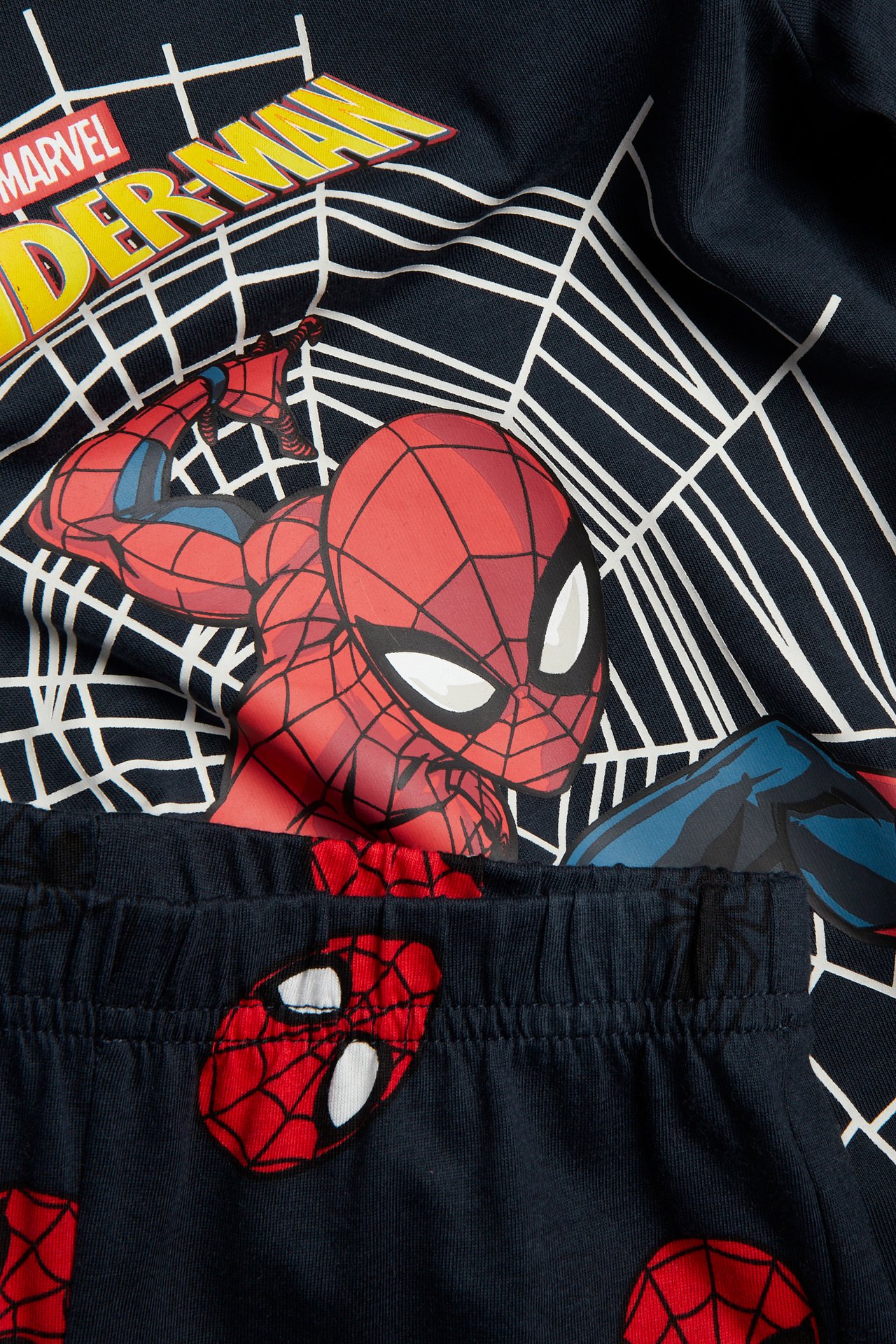 Nærbilde: mørkeblått Spider-Man pyjamas sett med trykt topp og bukse med maskedetaljer.