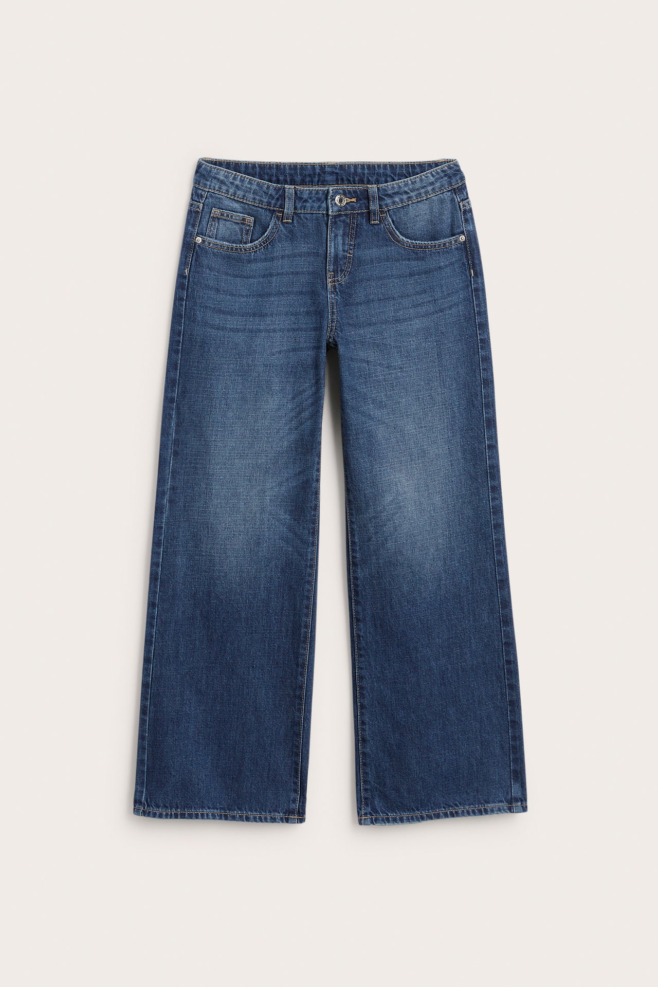 Framifrån: blåa jeans med vida ben, knappar, dragkedja och fem fickor.