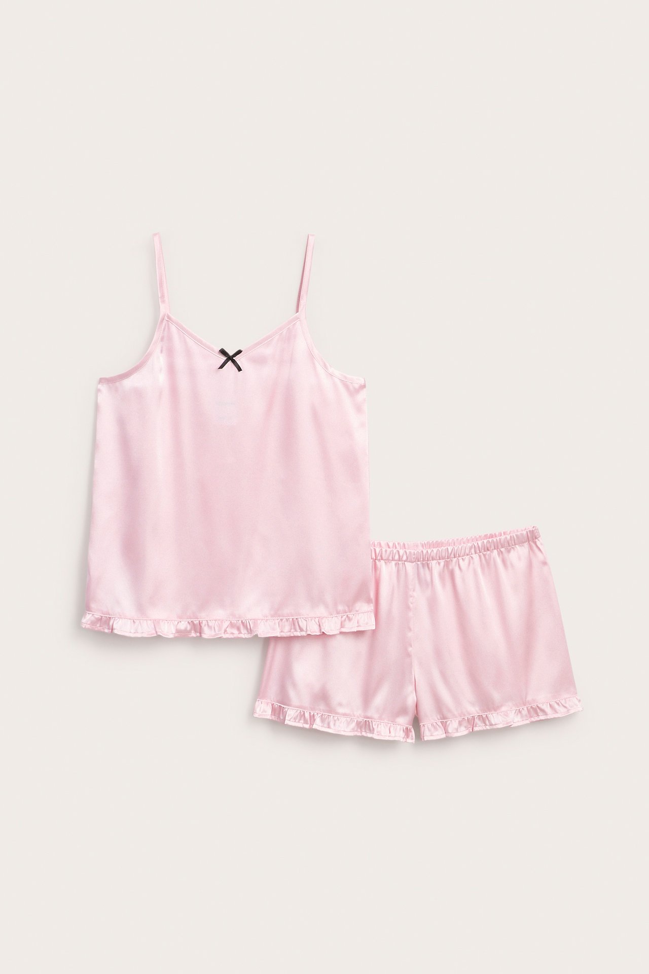Framifrån, rosa pyjamasset i satin med linne och shorts med volanger.