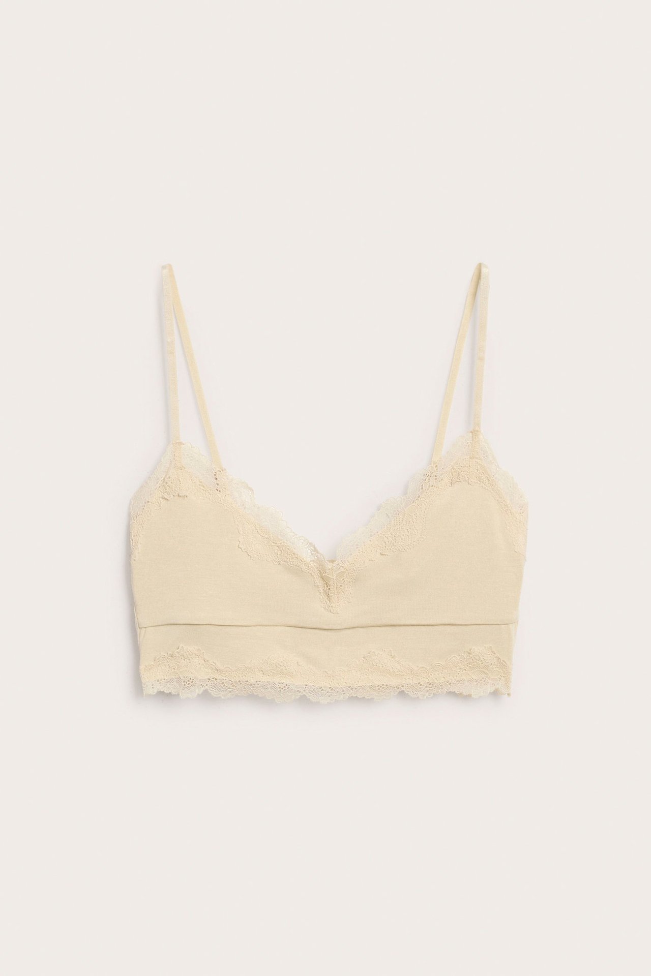 Forfra, en beige modal bralette-topp med blondedetaljer og justerbare skulderstropper.