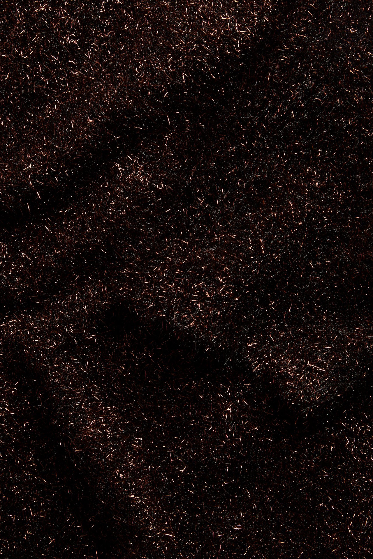 Närbild av ett mörkbrunt skimrande texturerat tyg.
