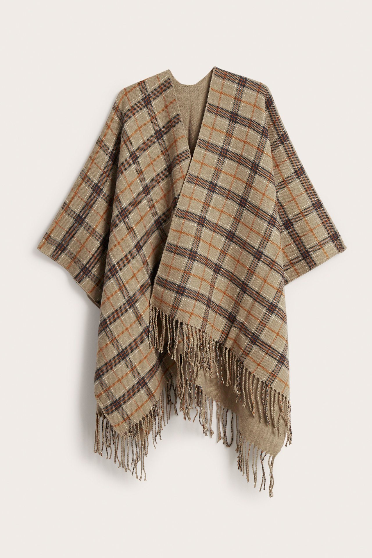 Front av en beige rutete poncho med brunt og oransje mønster og frynser.