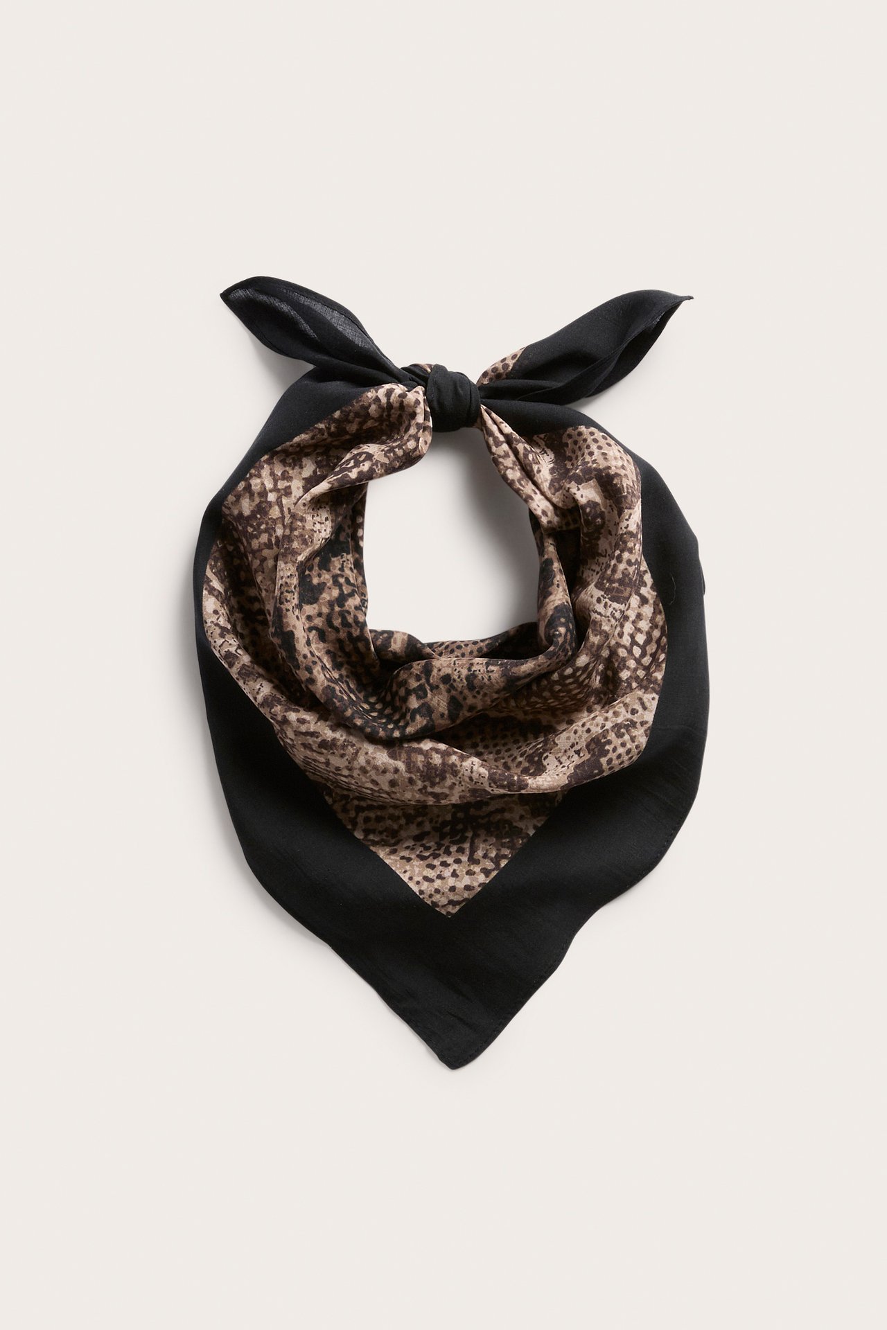 Edestä päin sidottu musta ja ruskea eläinkuvioinen bandana.