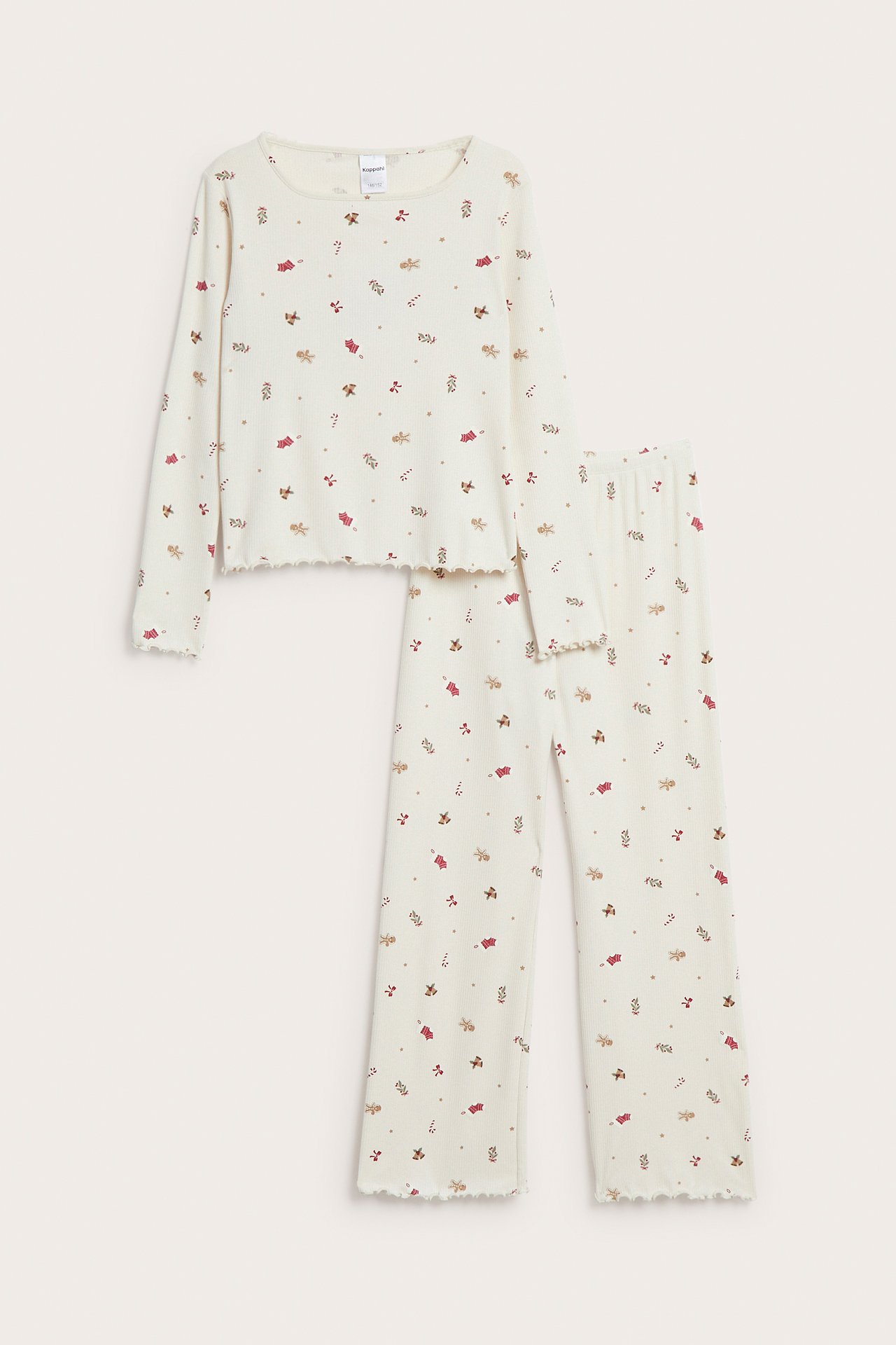 Frontbilde av barns kremfargede pyjamas med langermet topp og bukser, pepperkake- og polkagrisprint, bølgete kanter.