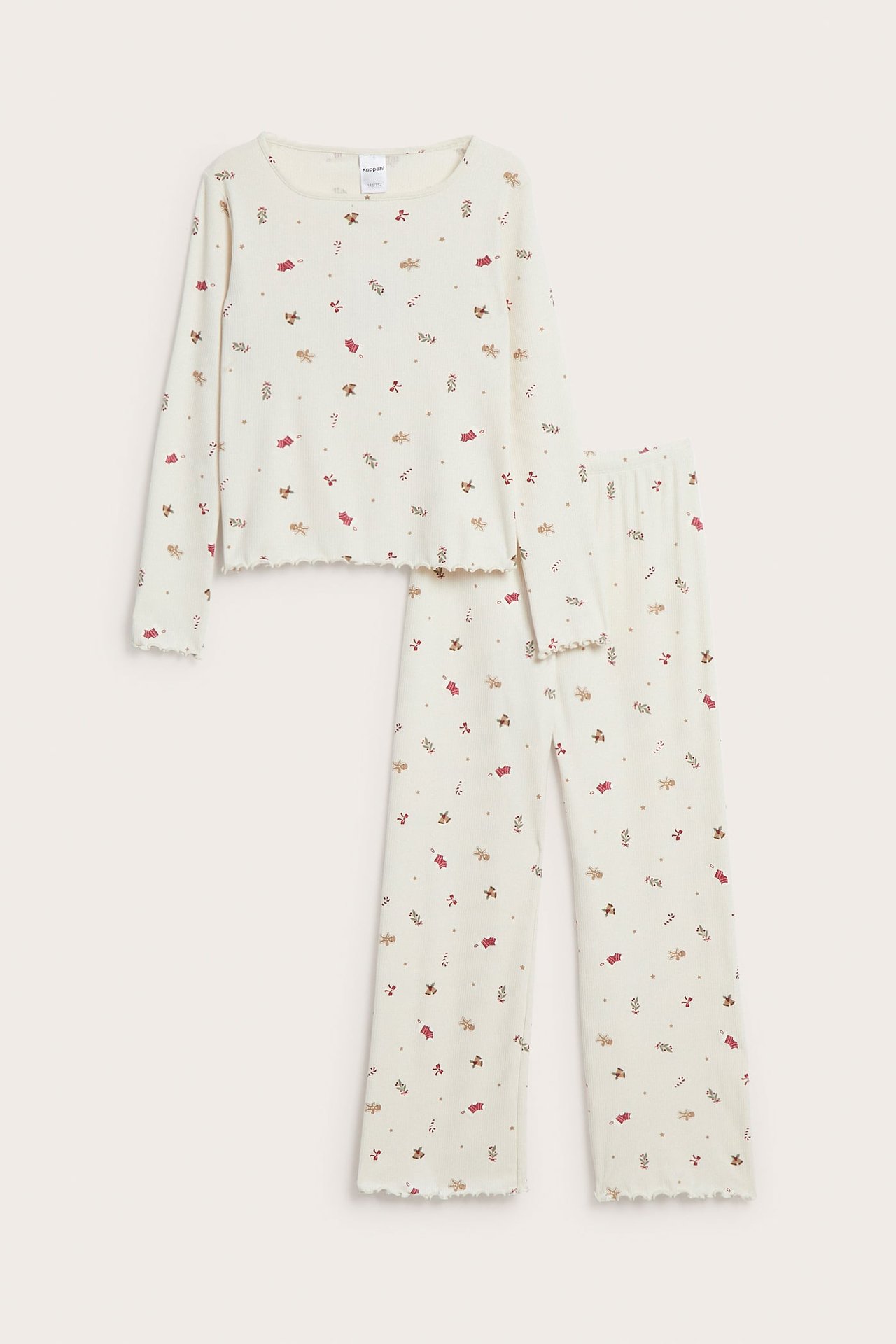 Frontbilde av barns kremfargede pyjamas med langermet topp og bukser, pepperkake- og polkagrisprint, bølgete kanter.