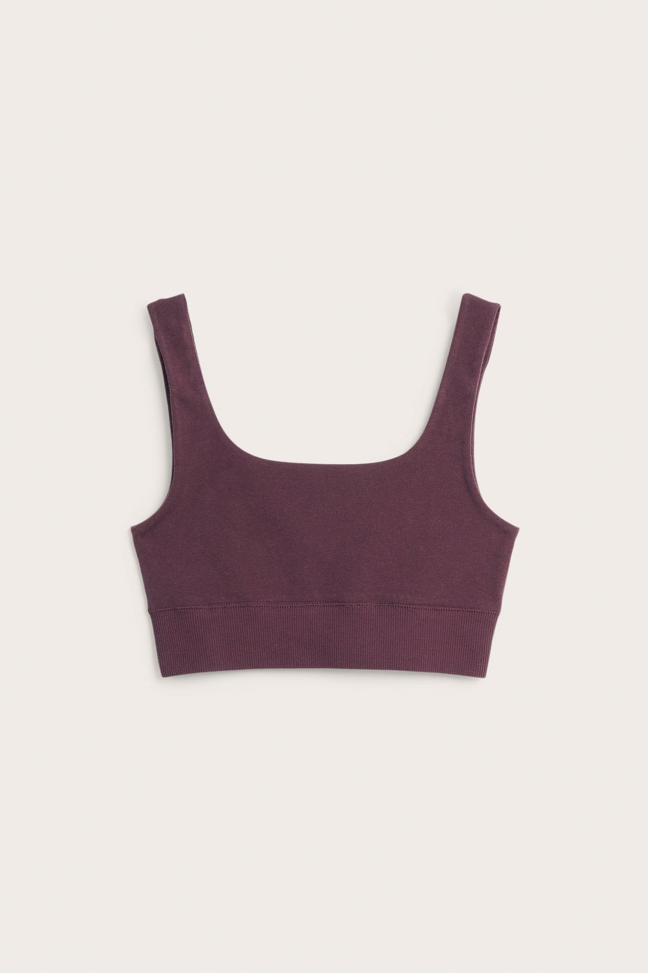 Framifrån, enfärgad mörkröd scoop neck bralette med breda axelband och ribbad nederkant.
