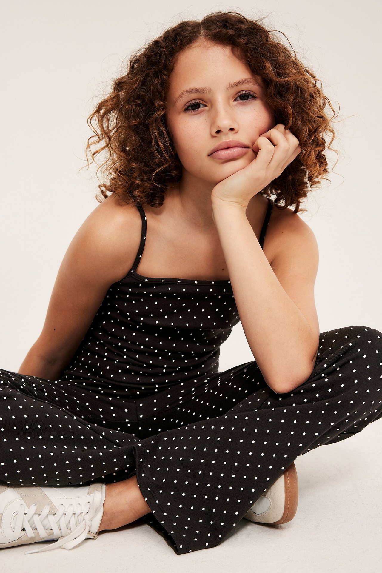 Widok z przodu: Dziecko w czarnym topie z cienkimi ramiączkami, w kropki, z pasującymi spodniami.