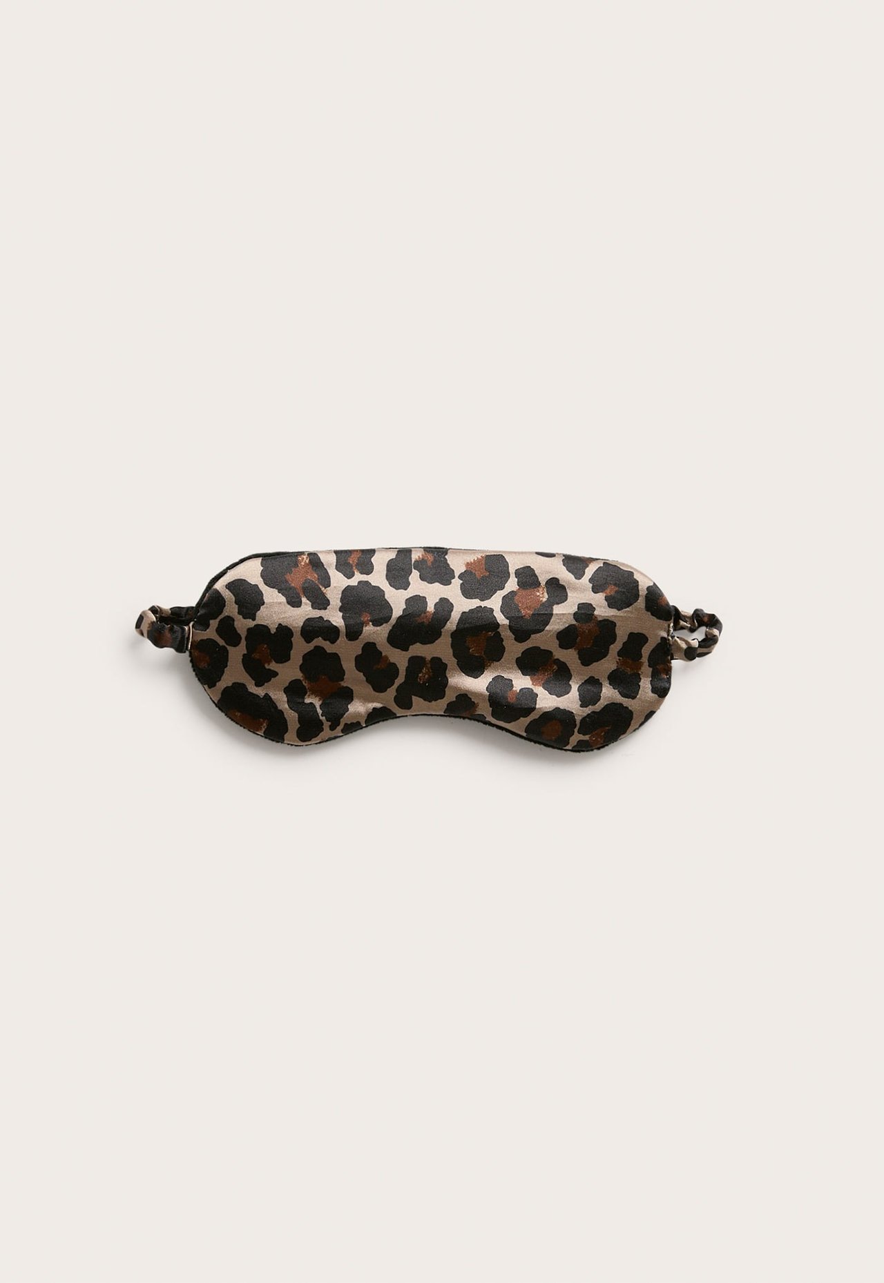 Flatt lagt leopardmønstret sateng sovemaske med brune, svarte og beige flekker.
