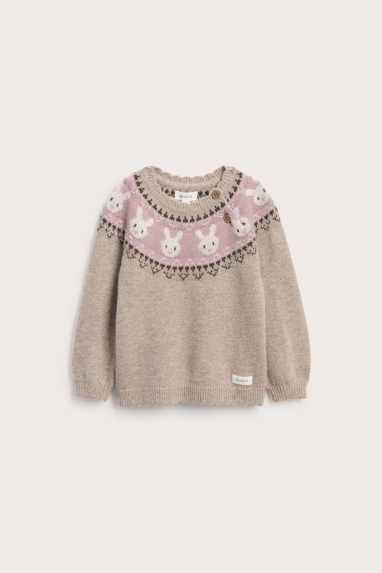 Forfra: babygenser i beige strikket med rosa fair isle kaninmønster og to brune knapper.