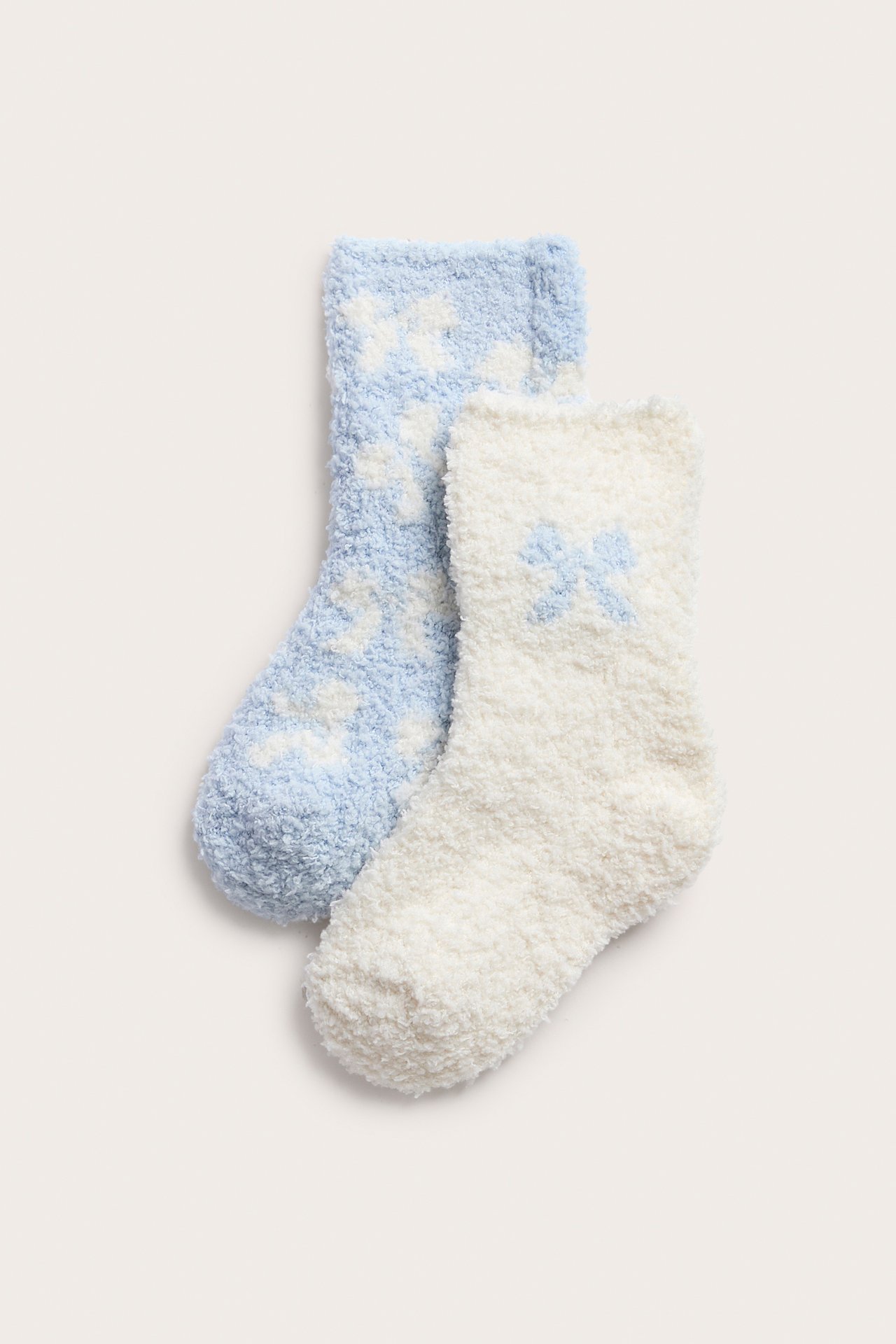 Framifrån, fluffiga blå stjärnstrumpor och fluffiga vita rosettstrumpor.