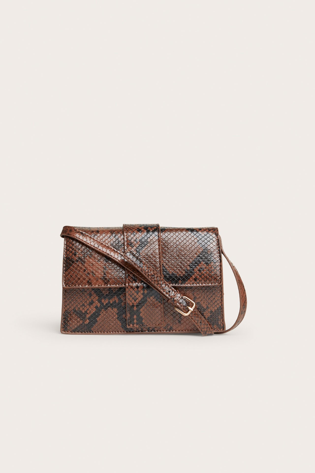 Framifrån: Brun och svart ormskinnsmönstrad crossbody-väska med guldfärgat spänne.