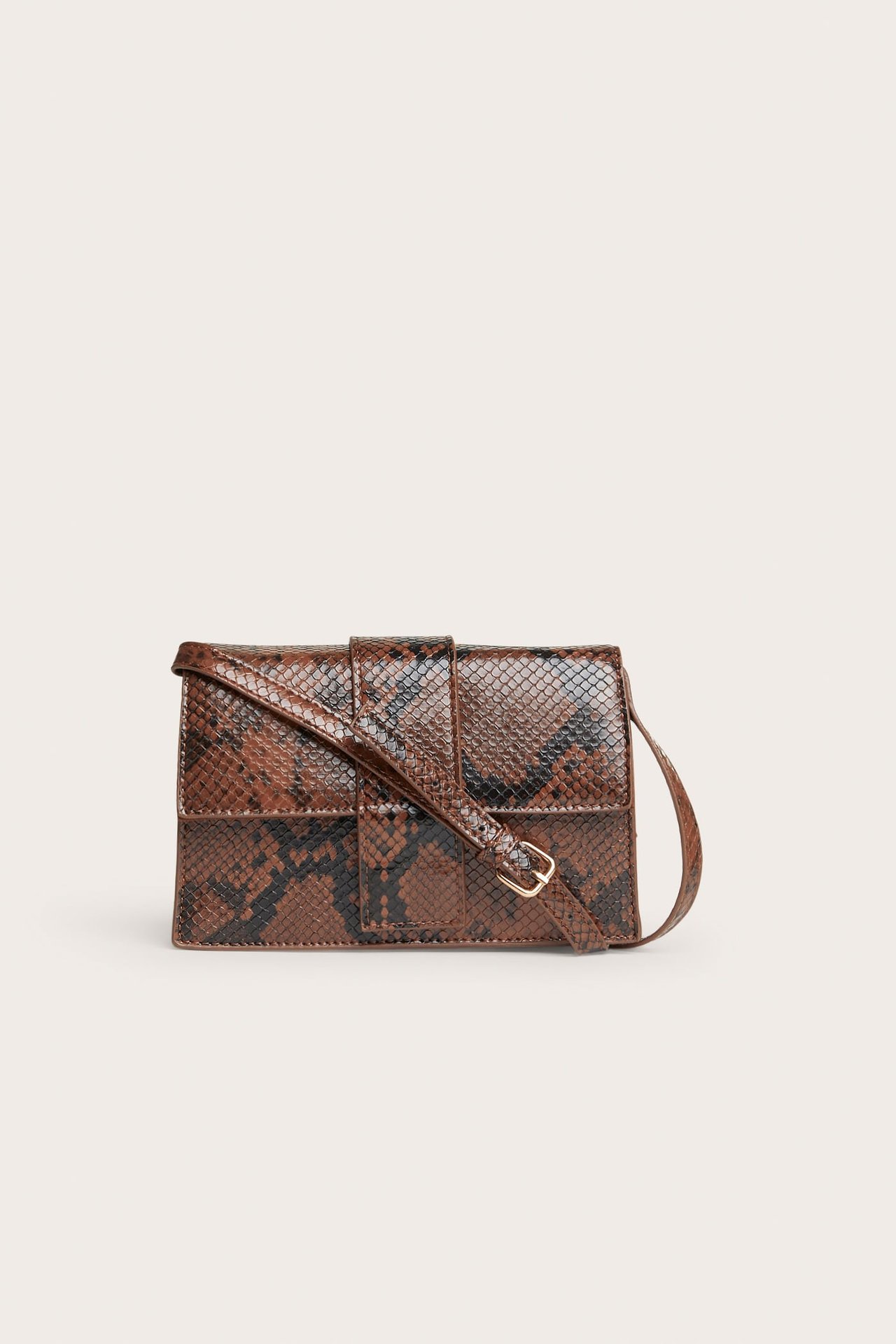 Framifrån: Brun och svart ormskinnsmönstrad crossbody-väska med guldfärgat spänne.