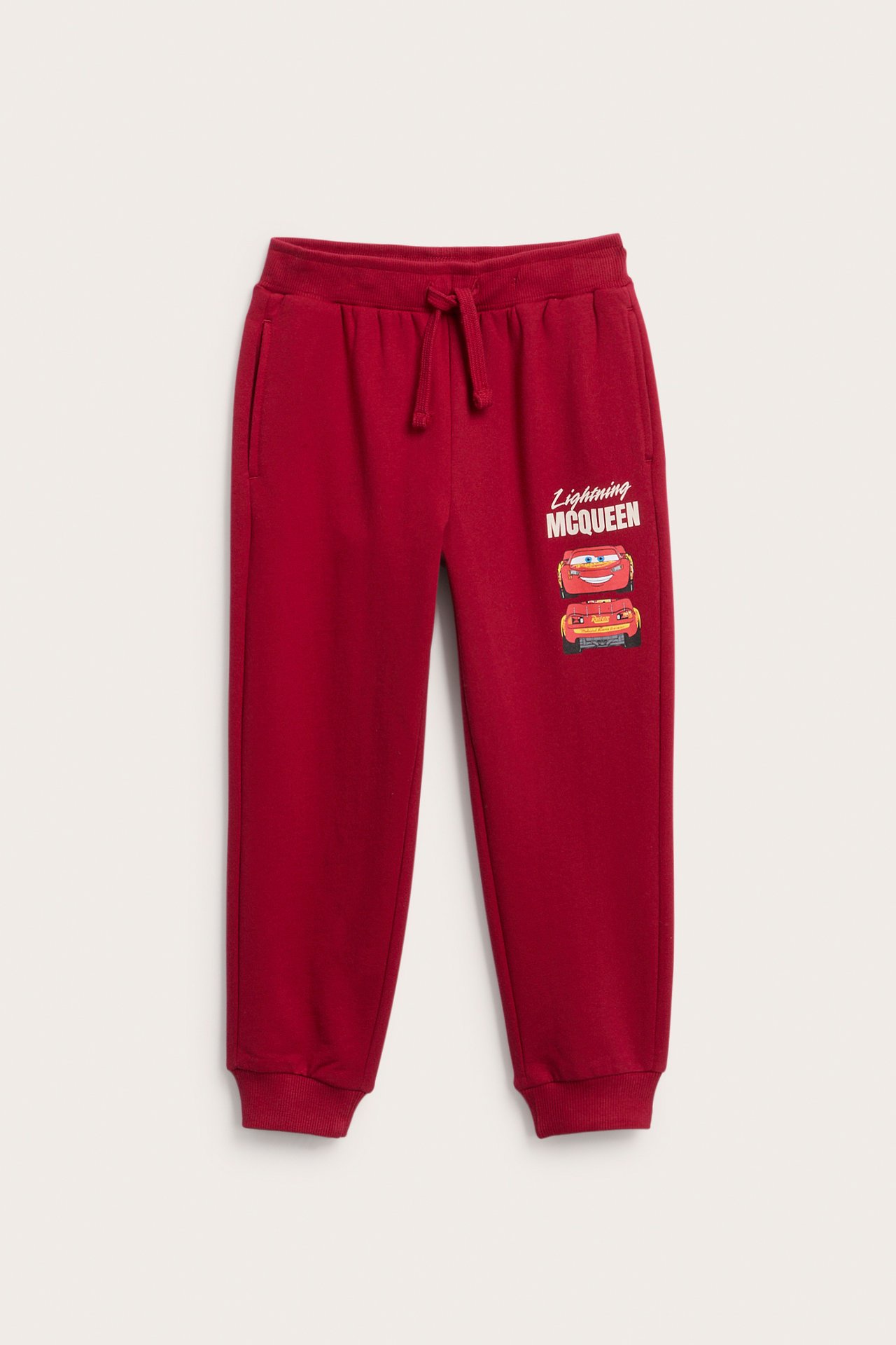 Forside av rød Lightning McQueen barnejoggebukse med snøring og ribbestrikkede mansjetter.