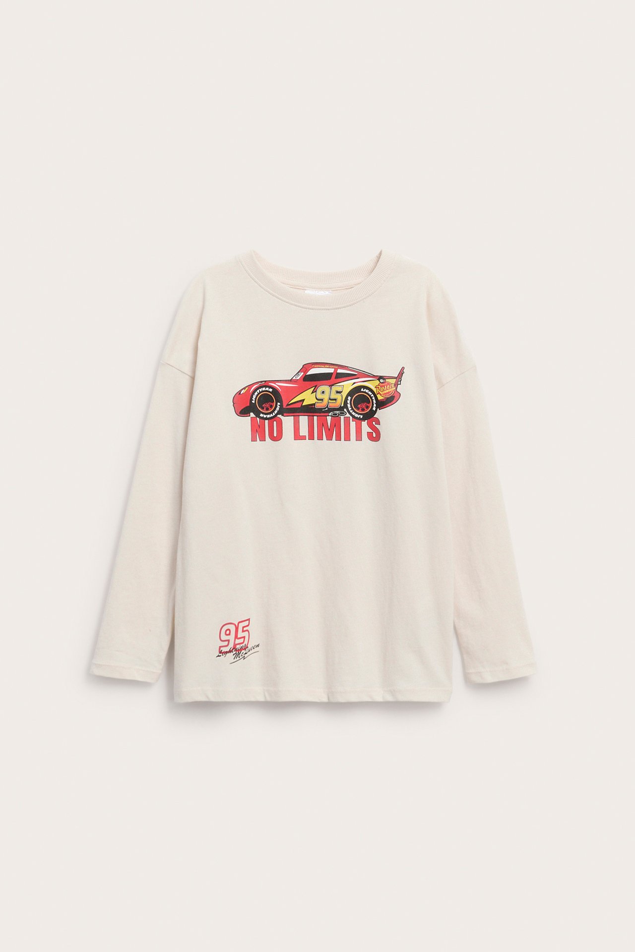 Frontbilde av en beige langermet barnegenser med Lightning McQueen-trykk og 'NO LIMITS' tekst.