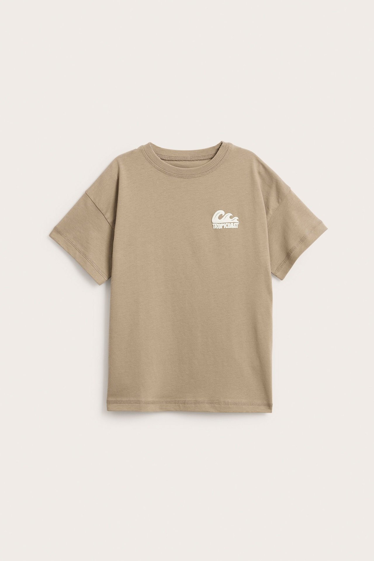 Widok z przodu brązowego bawełnianego t-shirtu oversize dla dziecka z białym nadrukiem na piersi.