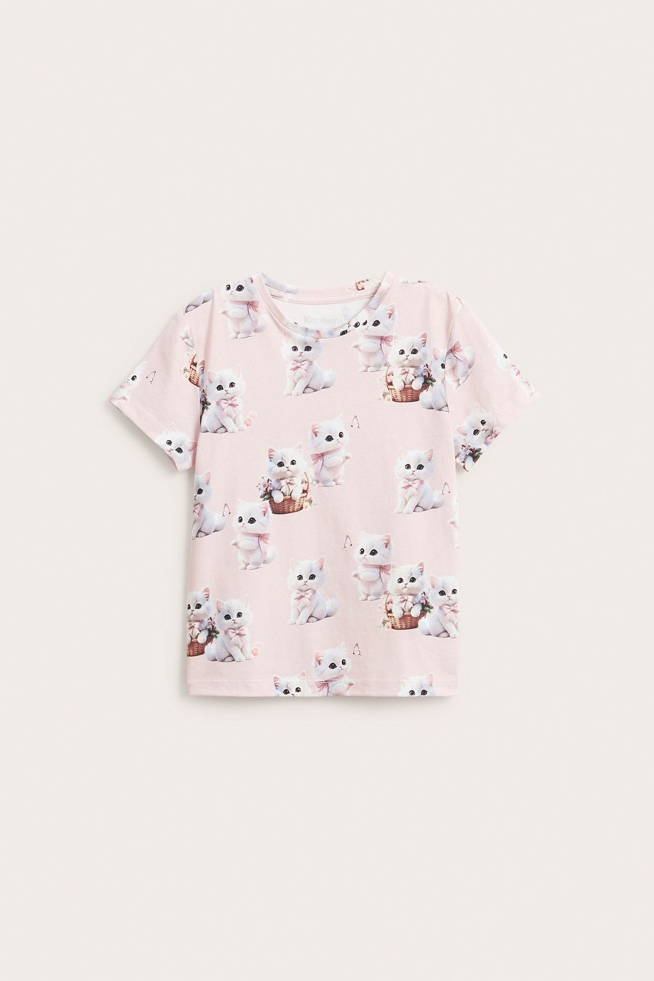 Widok z przodu: jasnoróżowy bawełniany T-shirt dla dziecka z uroczym wzorem w białe kotki.
